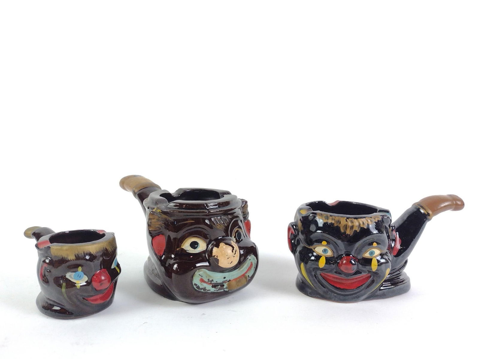 3 Black Americana Ashtray Pipes: One marked "Japan." Overall good condition with minor wear and tear associated with age. From 2" to 3" tall and 3-1/4" to 5-1/2" long.