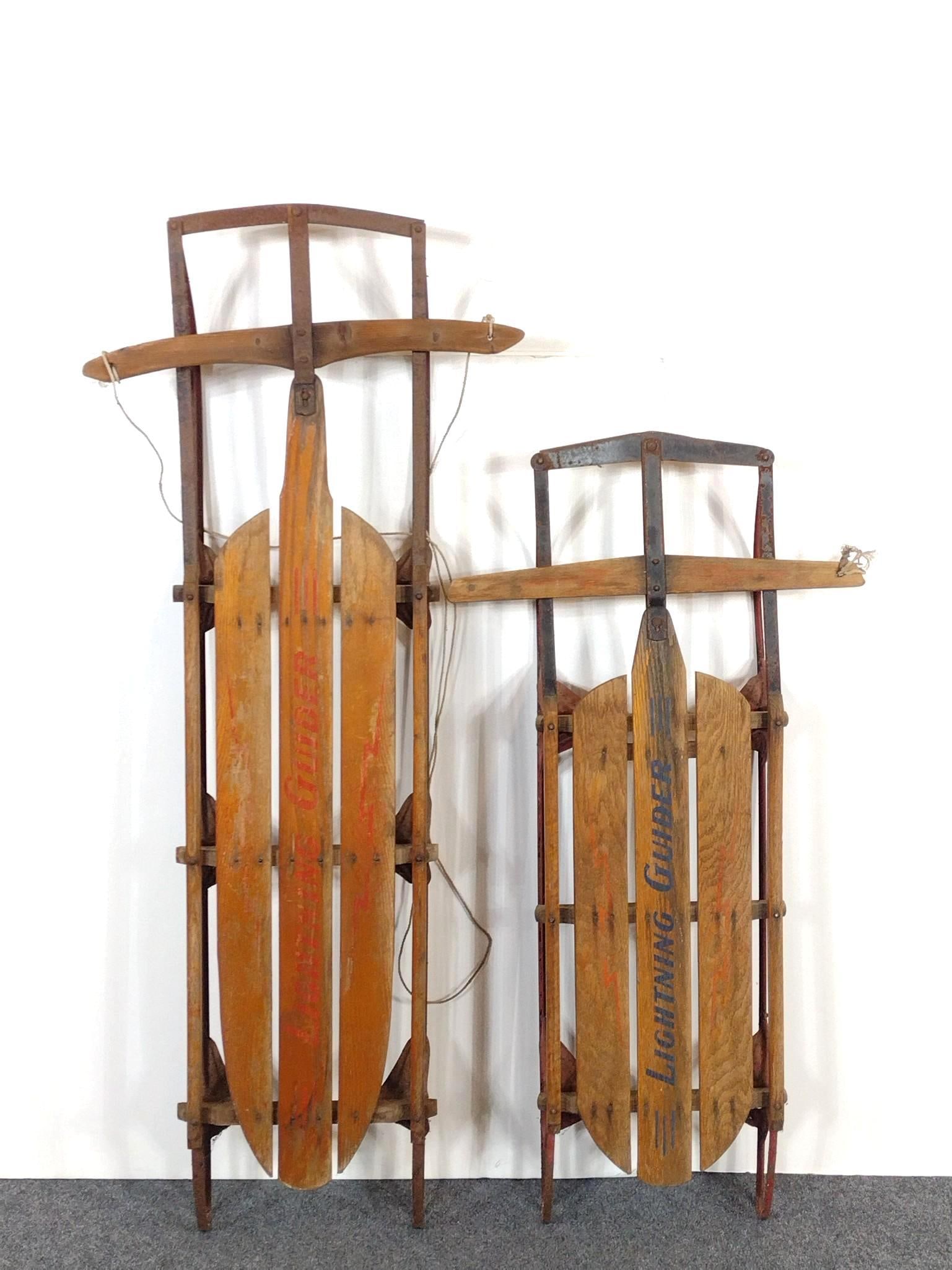 Two Lightning Glider Sleds: NOT ELIGIBLE FOR IN-HOUSE SHIPPING: See Terms for Shipping Options. 22" wide X 45-1/2" to 55-1/2" long. Both have finish loss and rust.