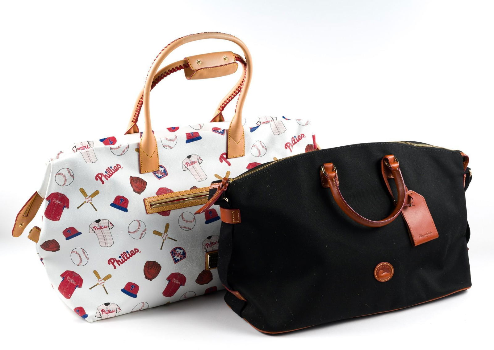 2 Dooney & Bourke Duffel Bags incl. Philadelphia Phillies: In good condition. 25" to 29" wide.