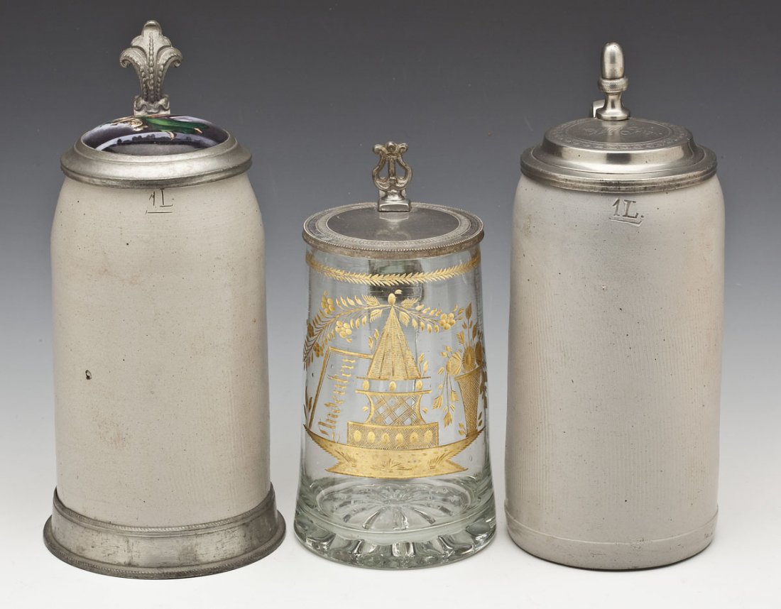 3 German Steins: DESCRIPTION: Three German steins including: 1) Glass and pewter stein with a cut glass bottom and etched design on the front filled in with gilt. Pewter lid and thumb lift. 7-3/8" high. 2) Stoneware a