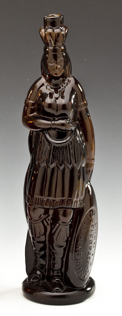 Brown's Amber Glass Indian Bitters Bottle: DESCRIPTION: Brown's dark amber glass Indian Queen herb bitters figural bottle. Rough lip and smooth base, embossed lettering on lower oval reserve marked, "Brown's Celebrated Indian Herb Bitters." Th