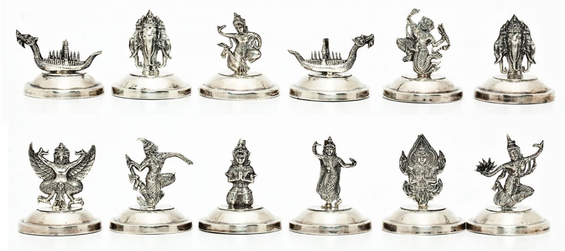 Set of 12 Siam Sterling Figural Place Card Holders: DESCRIPTION: Set of twelve Siam sterling silver figural place card holders on a round base. Each marked "Siam Sterling," on the bottom. MEASUREMENTS: Range in height from 1" to 1-1/2". Approximately 2