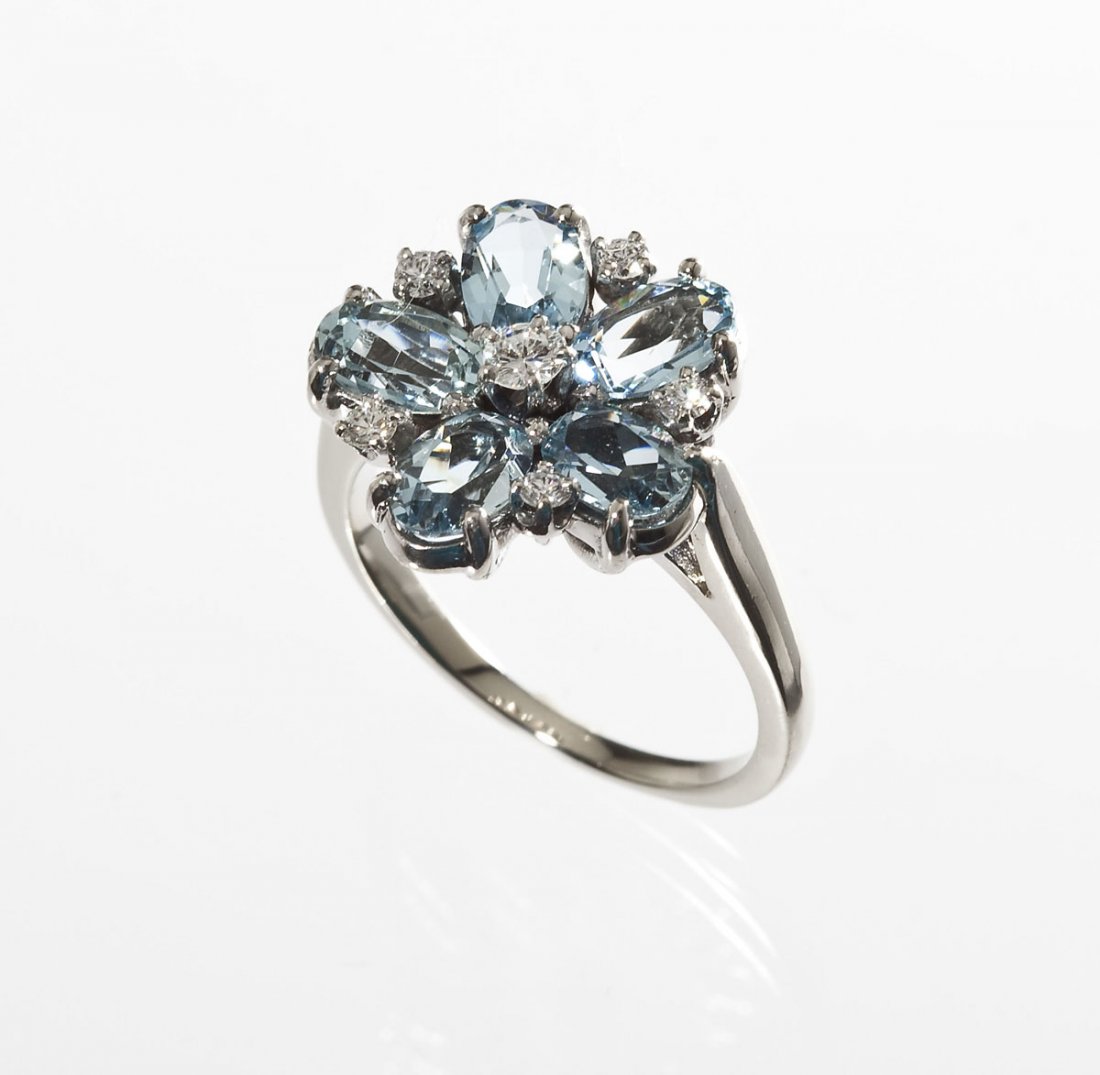 Blue Topaz & Diamond Flower Ring: DESCRIPTION: Blue topaz and diamond flower ring in marked 14K white gold. Set with a central .10 carat round brilliant cut diamond. Clarity VS1, color G. Surrounded by five 6.10mm x 4.05mm oval facete