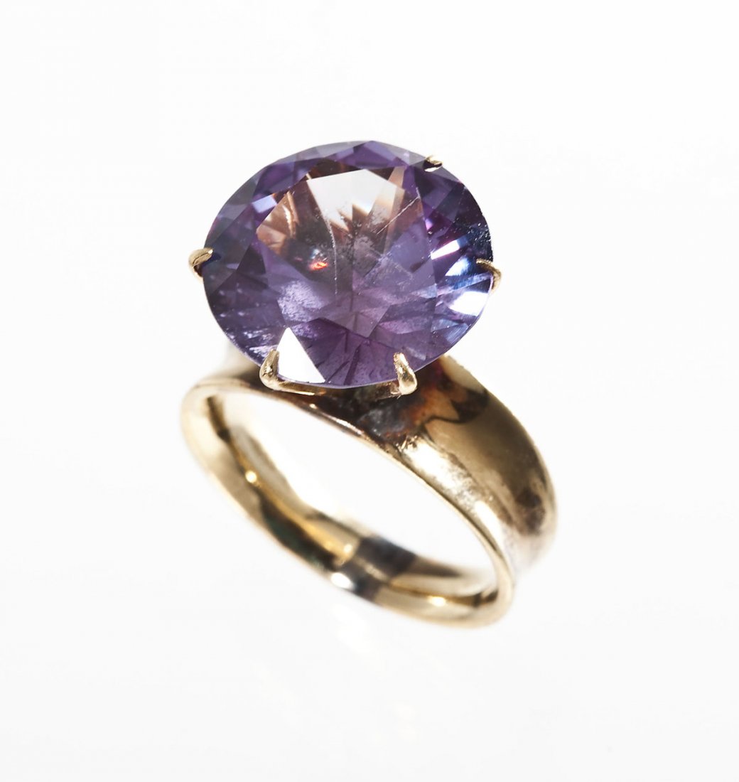 14K & Simulated Alexandrite Fashion Ring: DESCRIPTION: Simulated alexandrite ring in 14K yellow gold. Set with a 14mm round faceted simulated alexandrite stone. Size 6. 5.4 dwt (8.4 gr). CONDITION: Repair at base of shank.