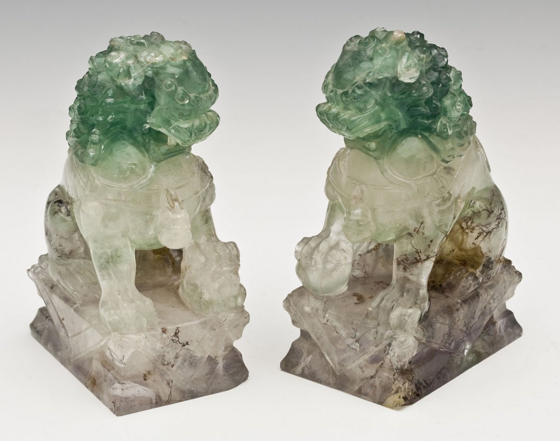 Pair of Chinese Carved Fluorite Foo Dogs: DESCRIPTION: Pair of Chinese carved fluorite foo dogs on plinthe bases and carved wood stands. MEASUREMENTS: Each 4-3/4" x 2" x 2-3/4" without base. CONDITION: Each with a few small nicks to florite. 