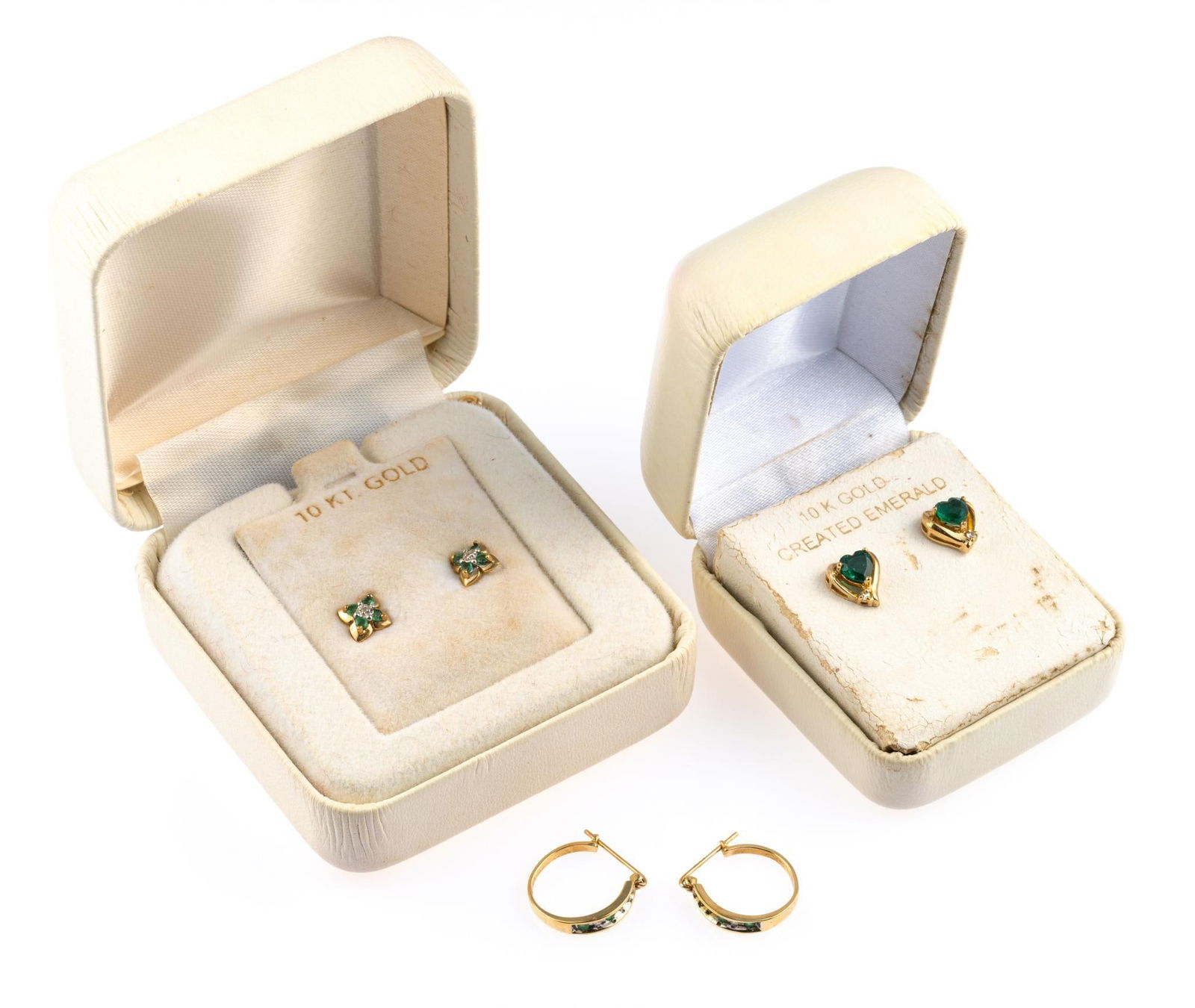 Three Pairs 10K Gold Earrings: Earrings include small hoops with melee size diamond and emerald, one stone missing, synthetic emerald heart shaped studs, floral studs. Total weight is 5.0 grams not including one of the backs which
