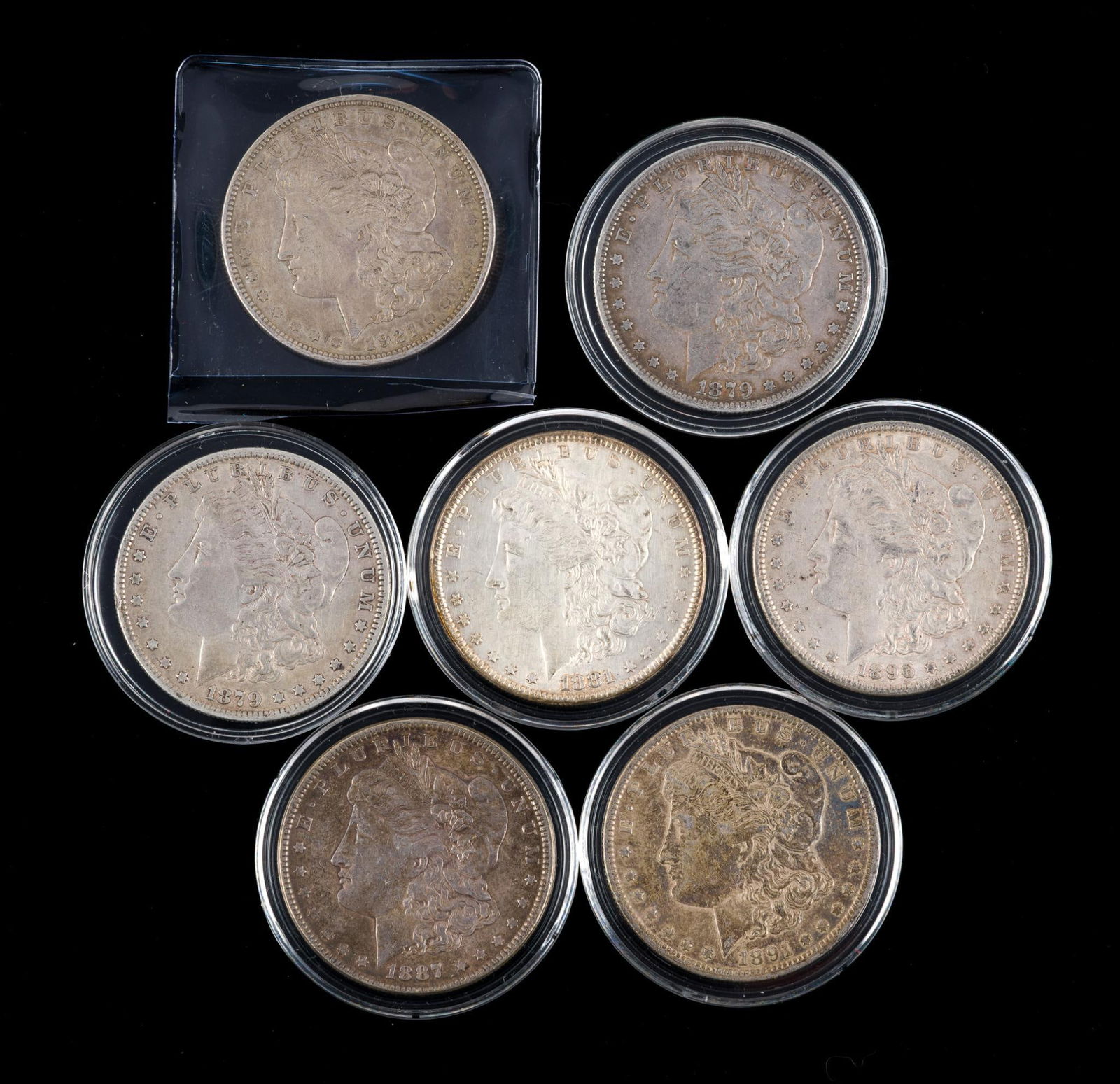 Seven Silver Morgan Dollars: Some better grades with one 1921 and the remainder 1800's coins.