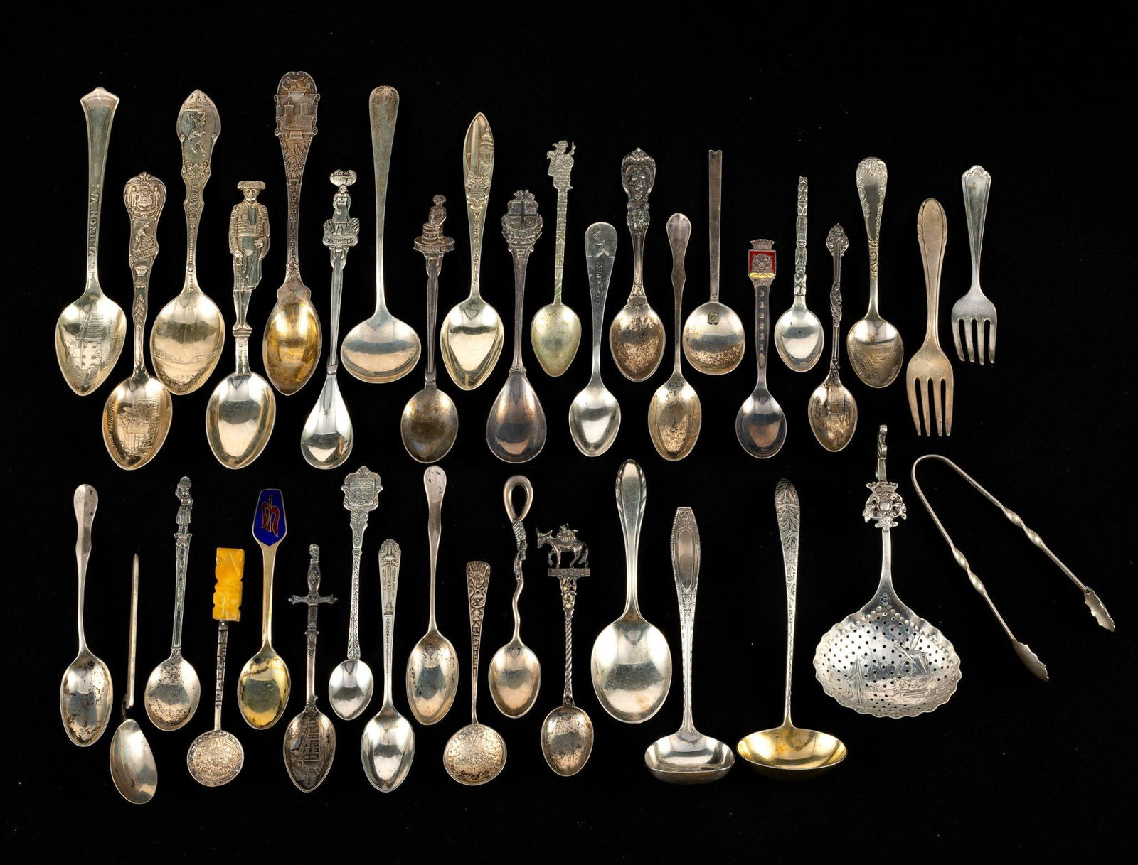 Sterling Silver Antique Spoon Collection: Over 35 sterling silver spoons with many being souvenir spoons. Pieces that are not spoons include a fork and sugar tongs. Total weight of sterling is 13.6 troy ounces. Additionally there are two