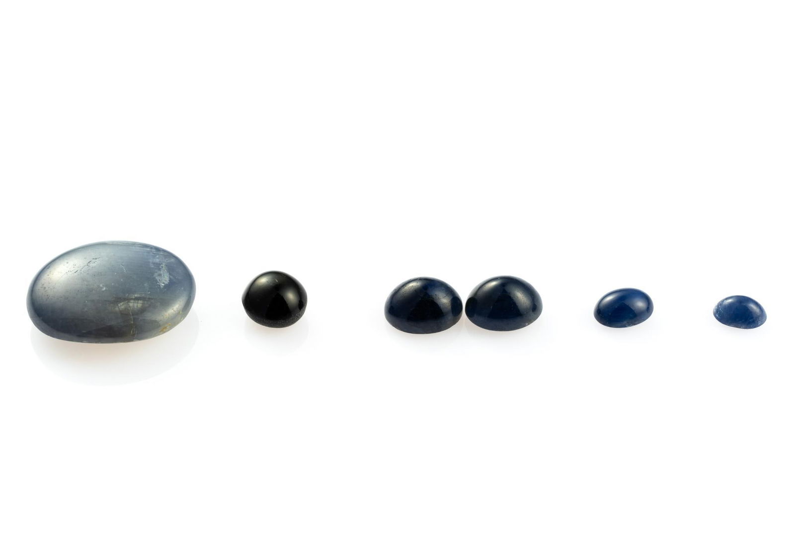 Five Sapphire Gemstones: 30.45 carat loose grayish blue oval cabochon star sapphire, Burma. 10 carat matched pair deep blue oval cabochon, Africa. 3.85 carat round cabochon black star sapphire, Africa. 1.07 carat oval cabocho