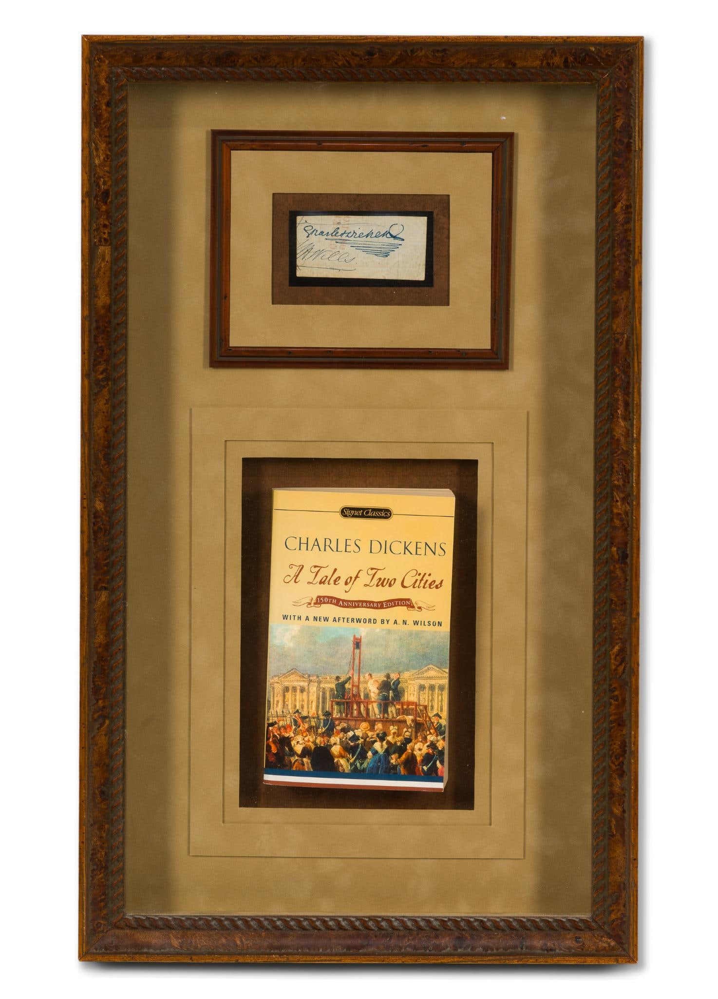 Charles Dickens Signature w/ A Tale of Two Cities: NOT ELIGIBLE FOR IN-HOUSE SHIPPING: See Terms for Shipping Options. Signature framed in a shadow box with a copy of A Tale of Two Cities. Charles Dickens was an English writer and journalist. He creat