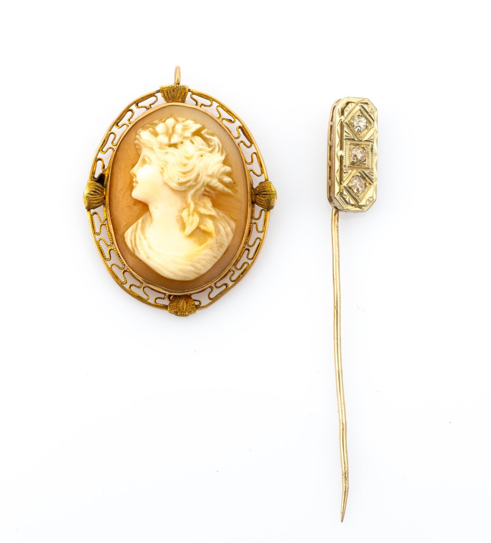 Antique 14K Gold and Diamond Pin and Cameo Pendant: A white gold pin testing 14k with three old mine cut diamonds with the length of the head being 5/8". Also a 1 1/4" length cameo pendant with a gold bezel testing 14k. The pin weighs 1.6 grams and the