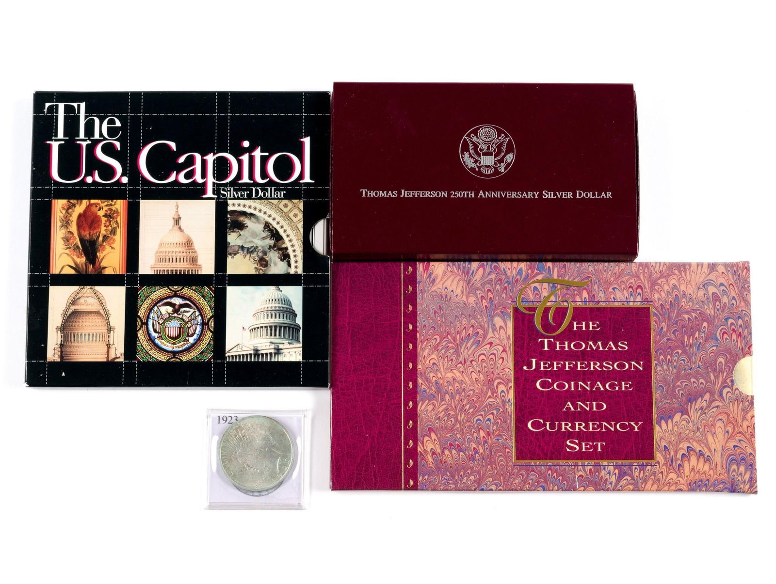 Commemorative and Peace Silver Dollars: Three commemorative silver dollars and one Peace dollar.