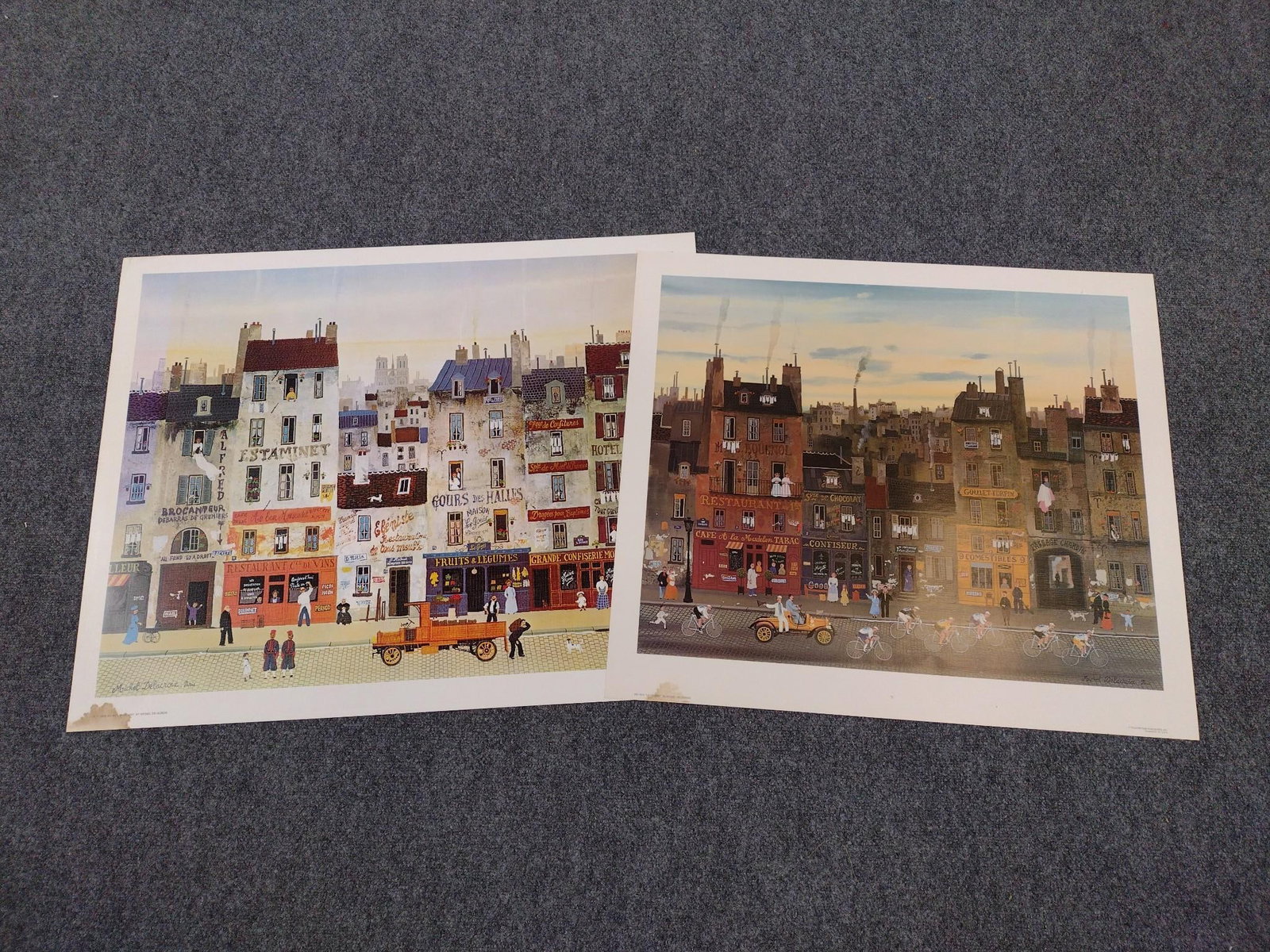 2 Michel Delacroix Prints Incl "Au Bon Mascadet": Also includes "La Course". 25" to 26" high X 28-1/2" to 32-1/2" wide. Both have water damage in bottom left corner. Unframed.