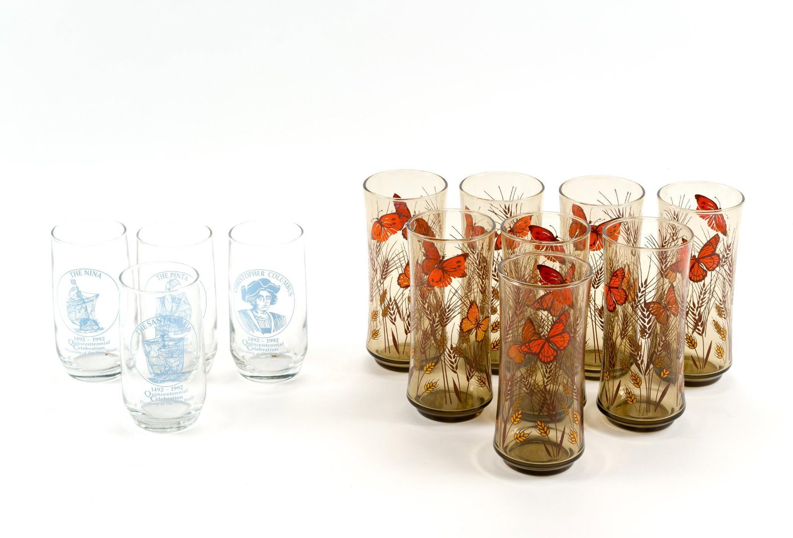 Set of 4 Christopher Columbus and 8 Butterfly Glasses: Columbus glasses are 2 - 1/2" in diameter and 5" tall. Libbey "Butterfly and Wheat" patterned glasses are 3" by 6 - 1/2".