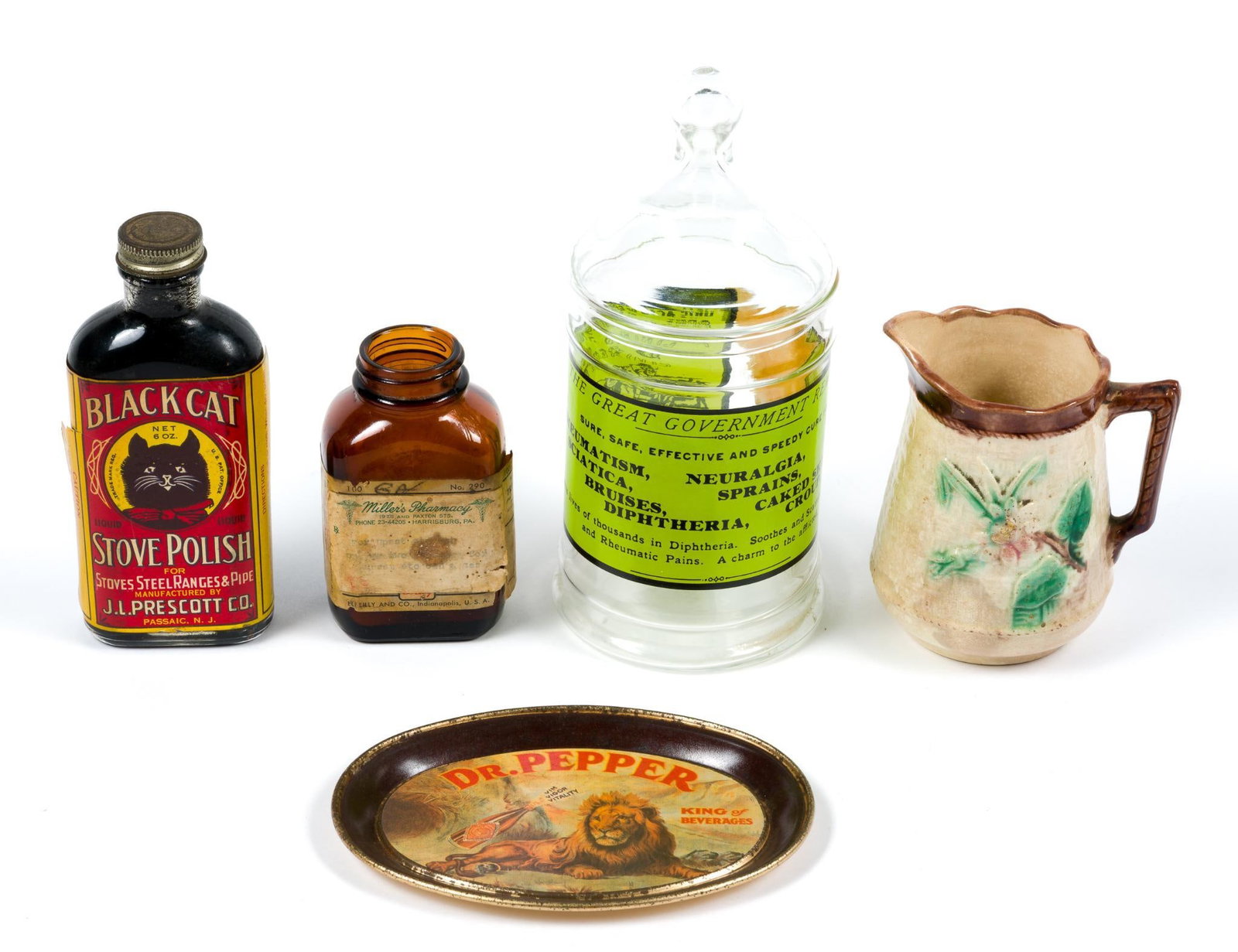 Vintage Decor and Advertising: Includes Black Cat Stove Polish glass bottle, an apothecary bottle and a medicine bottle from a pharmacy in Harriburg, PA, a Dr. Pepper advertising coin tray and a small Majolica pitcher.