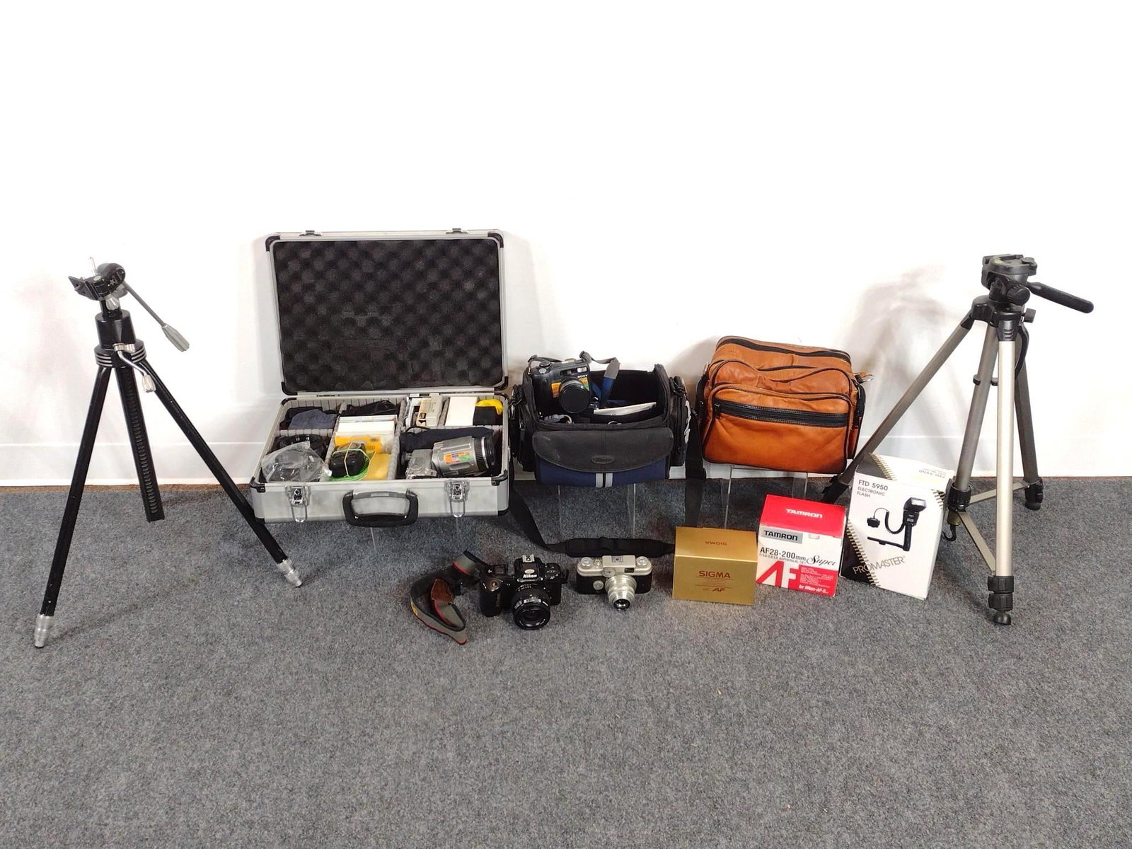 Cameras, Tripods and Film: Largest box measures 18" x 6" x 12 - 1/2". Includes a vintage Sony Cyber-shot camera, a vintage rangefinder camera, 2 tripods, a Nikon F-401S 35mm SLR film camera, a Promaster FTD 5950 Electronic Flas