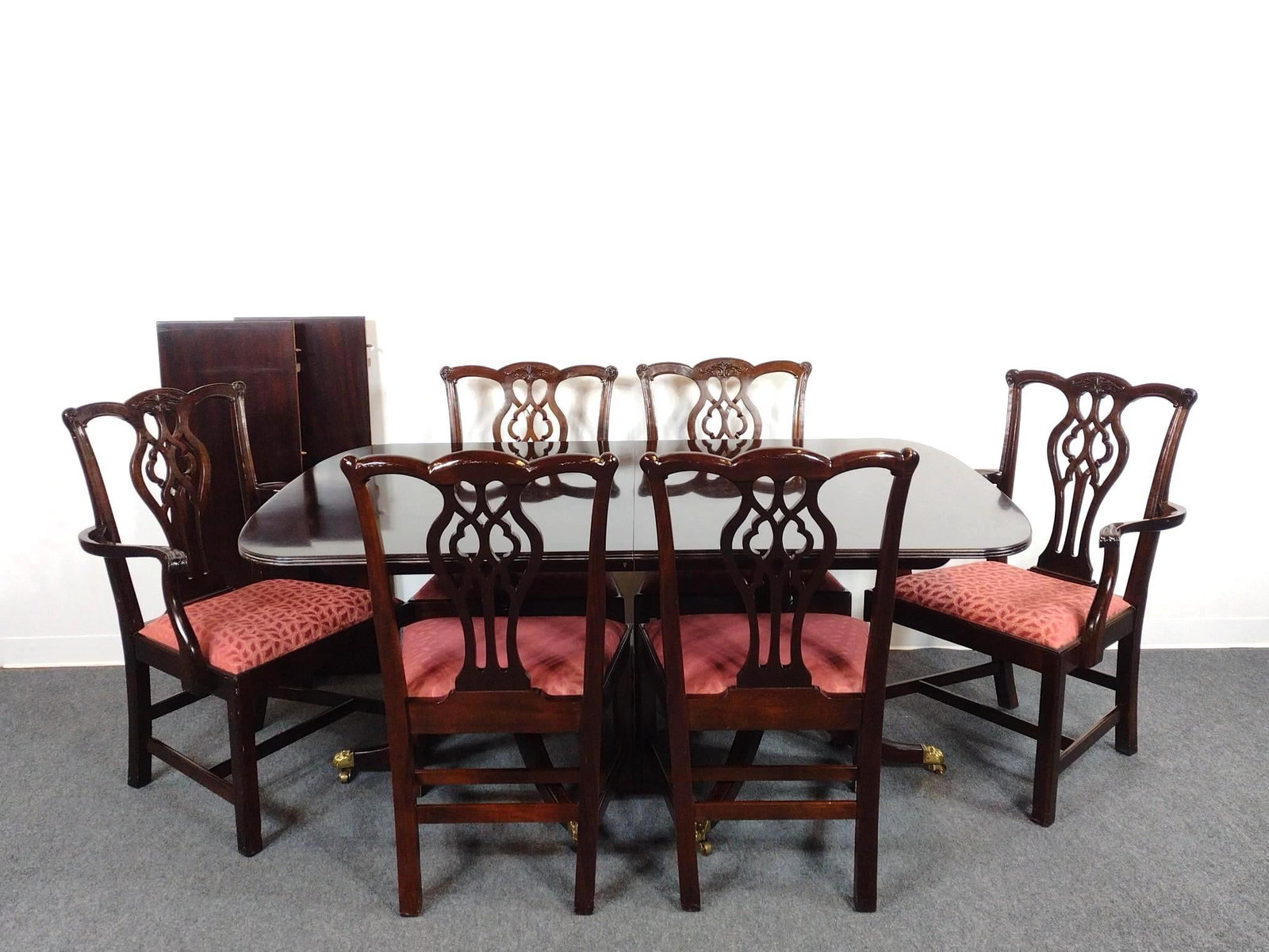Stickley Chippendale Style Dining Set: Double pedestal extension table with tripod legs and brass paw feet on casters. Pierced splat chairs. Table 68" wide X 44" deep X 30-1/4" high. 2 table leaves, each 15" wide. Arm Chairs 26" wide X 21-