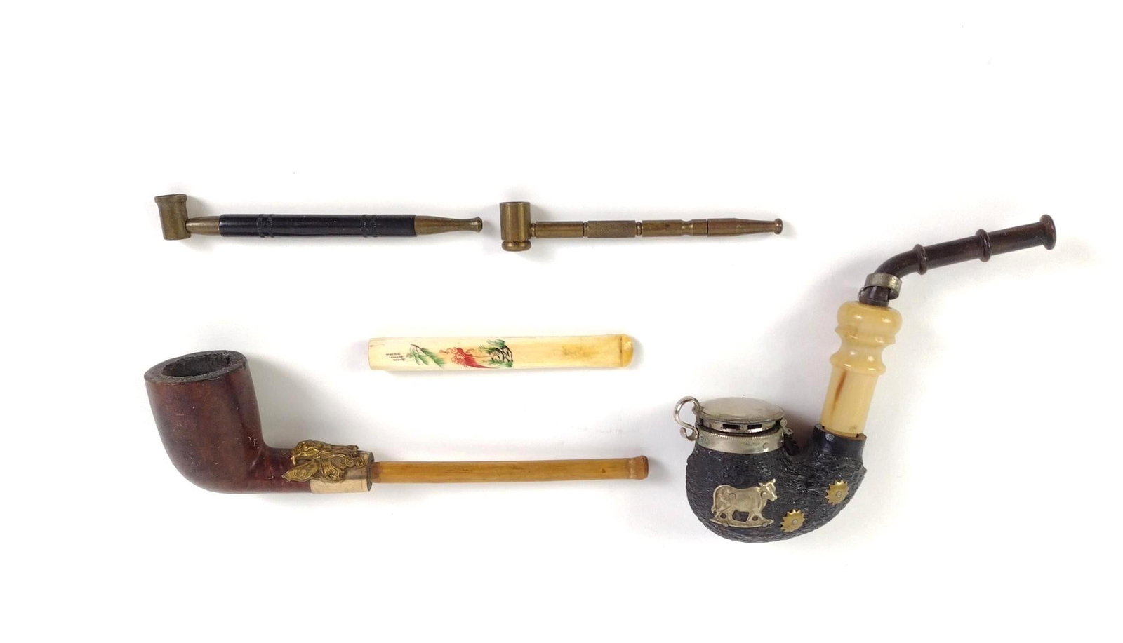 4 Vintage Pipes: Includes 2 vintage brass pipes, a William Demuth Company briar wood pipe, a cigarette holder, and a vintage Swiss-made tobacco pipe. 3-1/2" to 6-1/2" long.