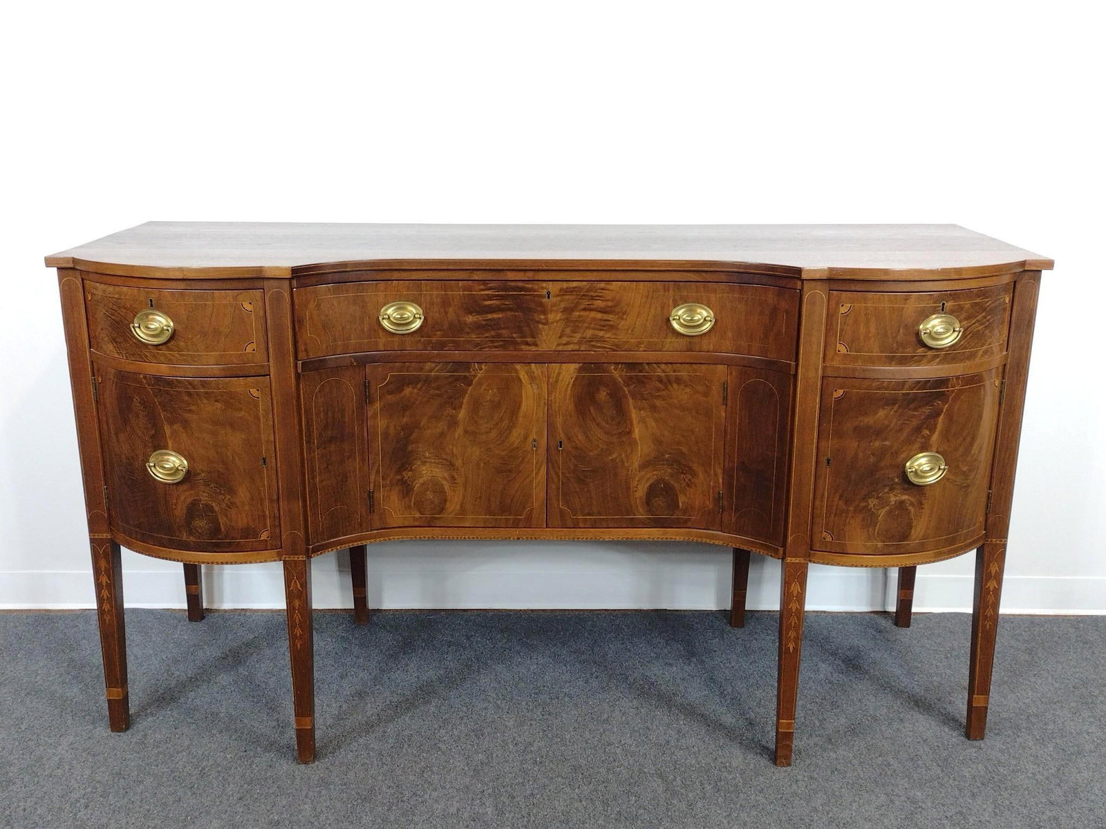 Hepplewhite Style Inlaid Serpentine Sideboard: 72" wide X 26" deep X 39" high. No manufactures name found.