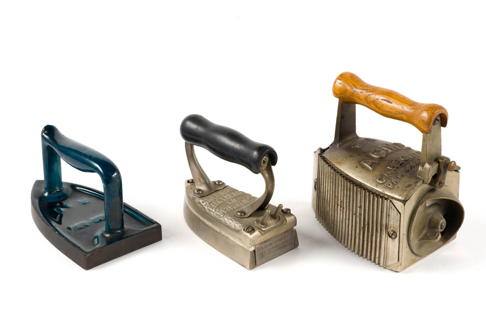 (Reconstruction Era) 3 Vintage Flatirons: From a private collection. Includes an Acme Carbon charcoal iron, which measures 7 - 1/2" x 3 - 3/4" x 7", an?antique American Electrical Heater Company electric iron which measures 5 - 3/4" x 2 - 3/4