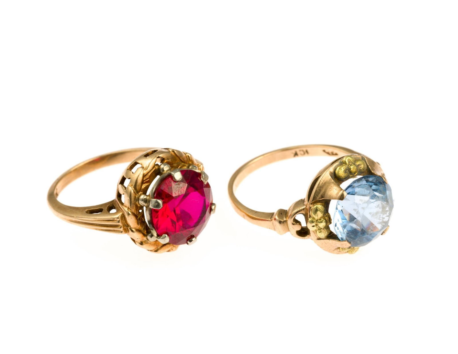 Two 10K Gold Gemstone Rings: A size 5.5 ring with red gemstone and a size 7 ring with blue rhinestone. The blue stone has chipping to the top. Total weight of the rings is 8.3 grams.
