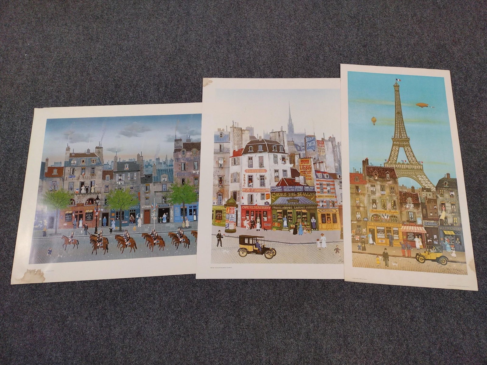 3 Michel Delacroix Prints Incl "La Gradie Republicaine": Also includes "Les Halles" & " Eiffel Tower". All have water damage on border. 26-1/2" to 35" high X 18" to 34" high. 