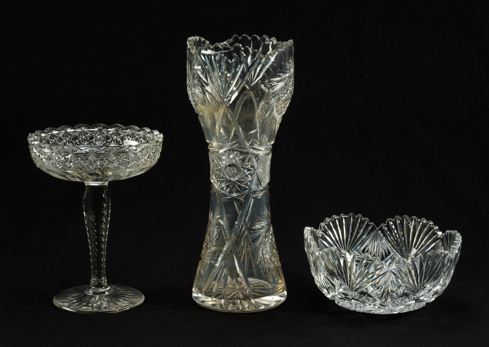 3 American Brilliant Cut Glass: Circa 1910. Includes a vase (14" high), a bowl (8" wide), and a tall compote. (~9" tall). All three in condition consistent with age and use. 