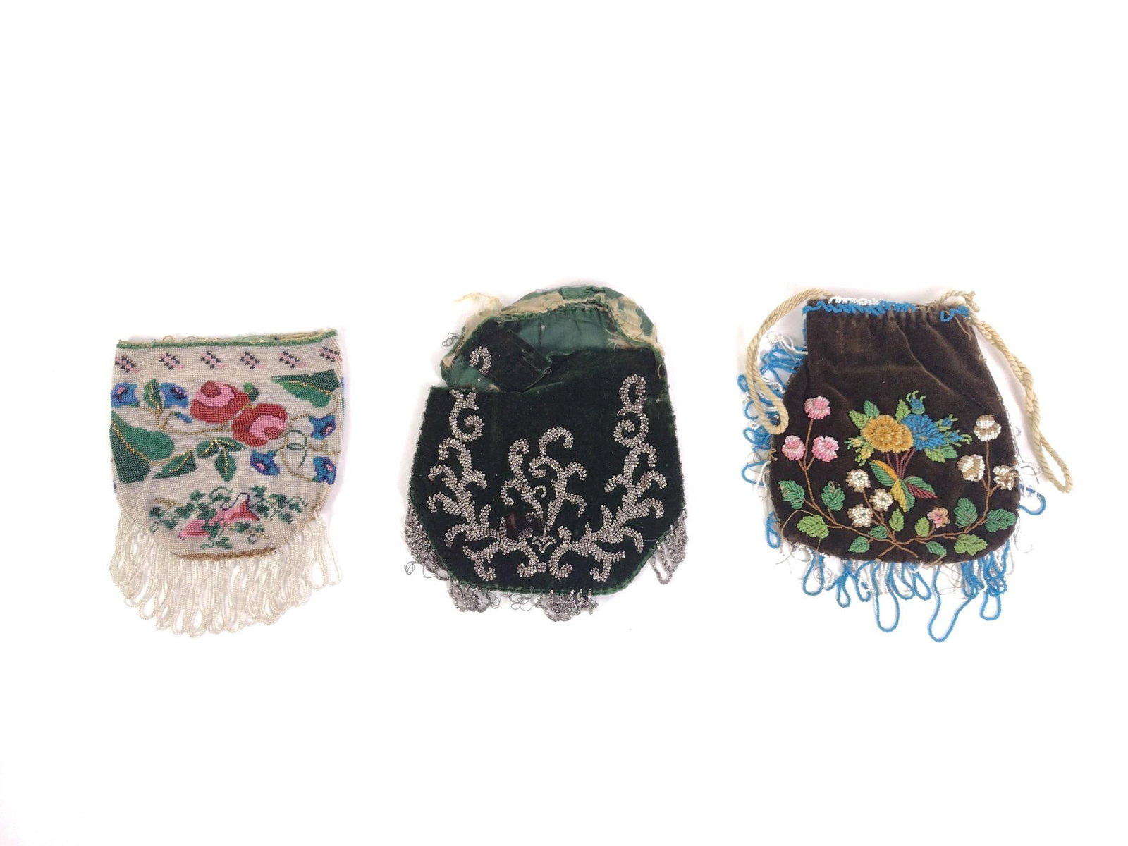 3 Beaded Flapper Purses: Green purse has dark stain and has losses to the top of the bag. Also includes a white beaded flapper bag and a brown cloth bag with beaded designs. Largest box purse is in measures 6" x 10" and box w