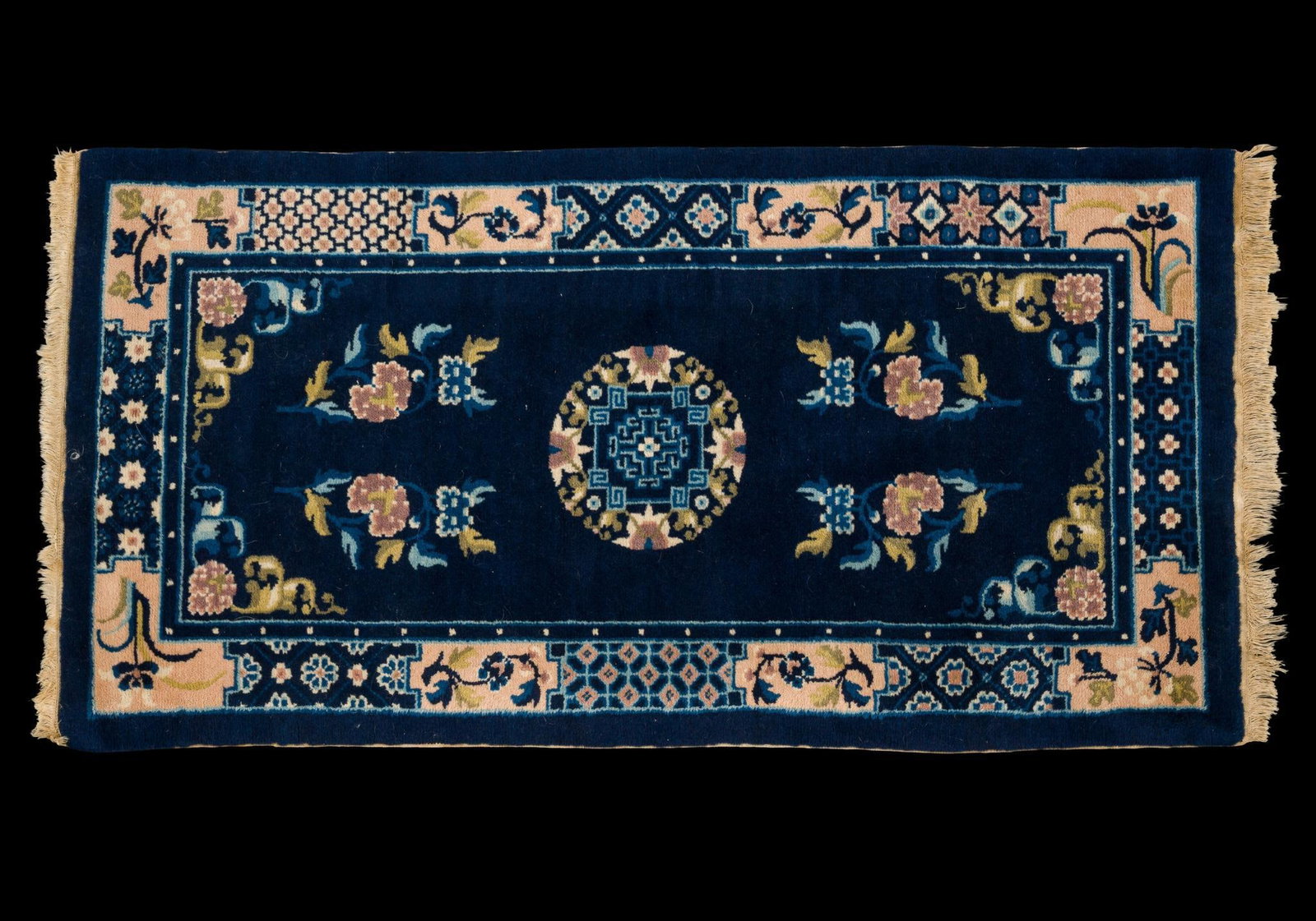 Chinese Peking-Style Wool Area Rug: Hand-knotted Chinese Peking-style wool area rug featuring a deep cobalt blue field centered with a round medallion and decorated with floral sprays in soft pink, ivory, celadon, and gold tones. The ru