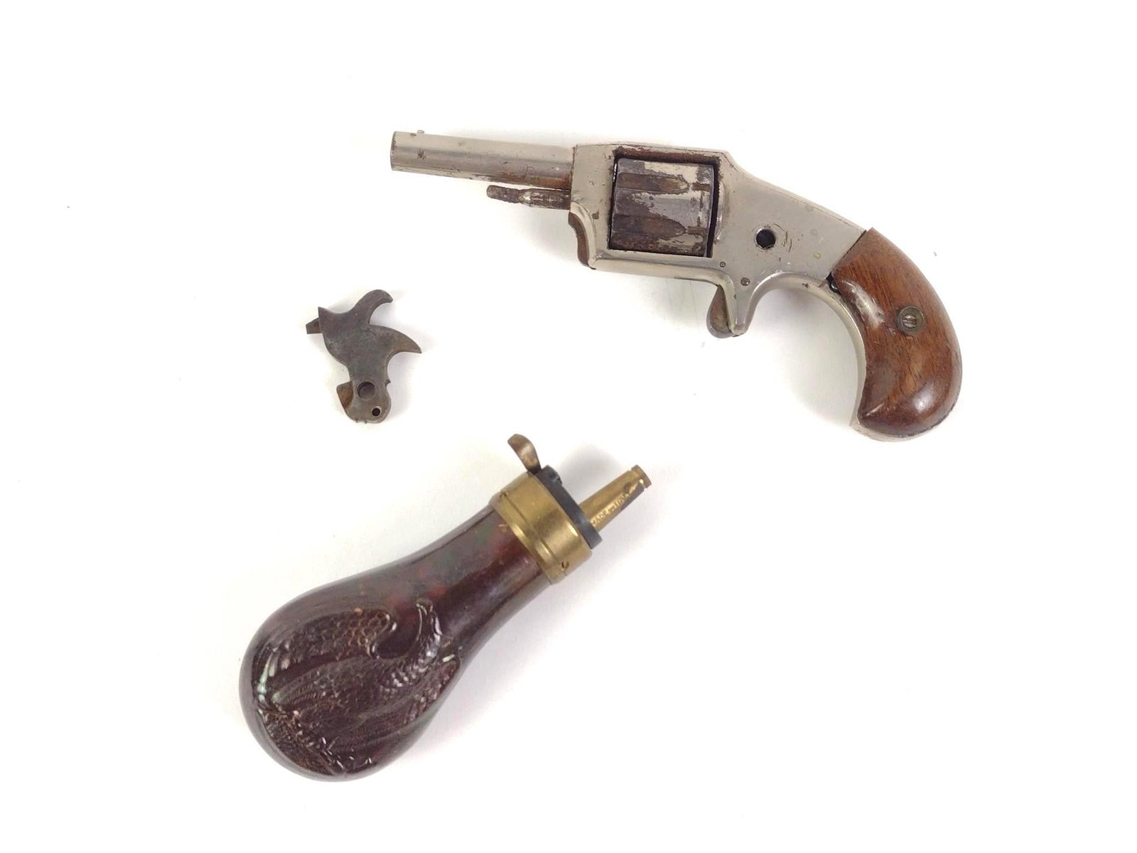 Vintage Defender Revolver and Baby Colt Pistol Powder Flask: Baby Colt pistol powder flask with the stamp "Made in Italy", in good condition consistent with age and use. Measures 4-1/4". Defender Revolver with detached spur, in condition consistent with