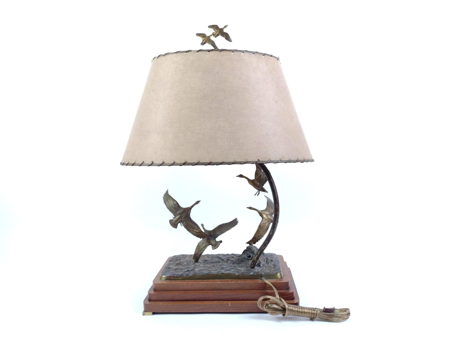 John F. Hansen Signed Table Lamp: Signed on base "John F. Hansen." This tall light has a tiered wooden base supporting the bronze sculpture by John F. Hansen (early 20th c.) of geese in flight, including two on the top finial. With ob