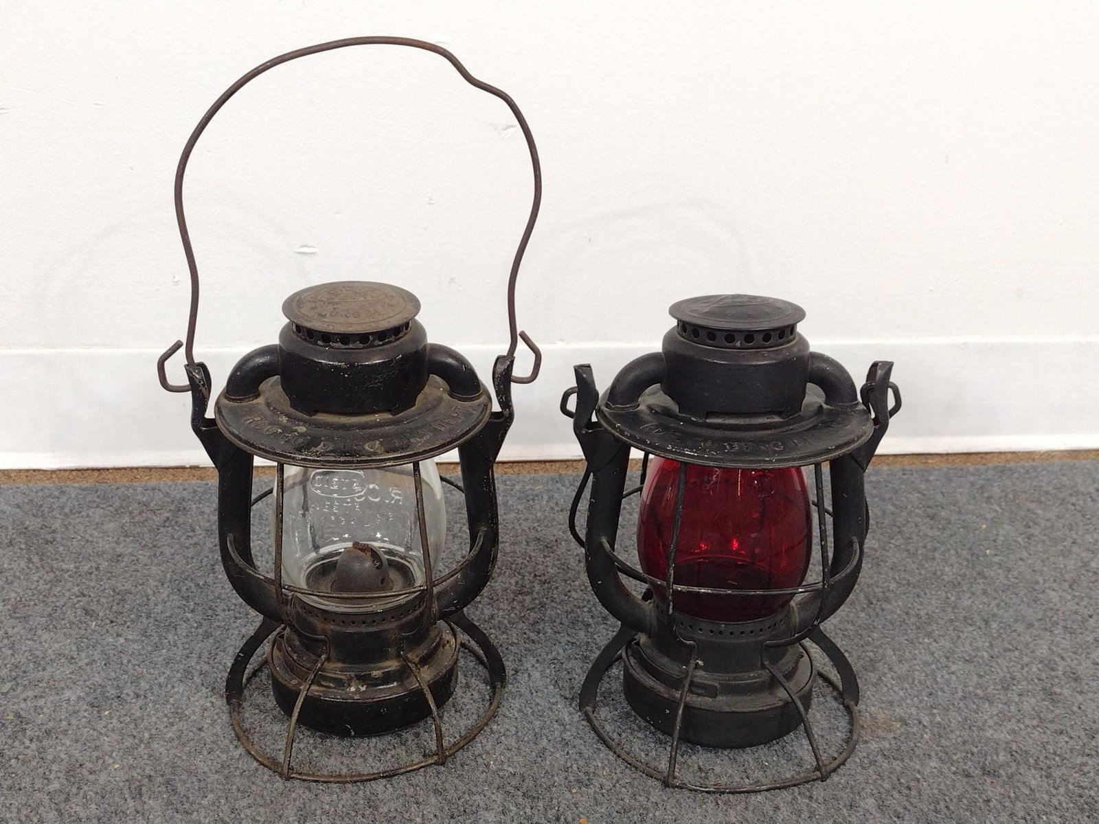 2 Railroad Lanterns: New York Central Railroad Dietz Vesta Lanterns, one red and one clear glass. Both with rust and wear. Measures ~15". 