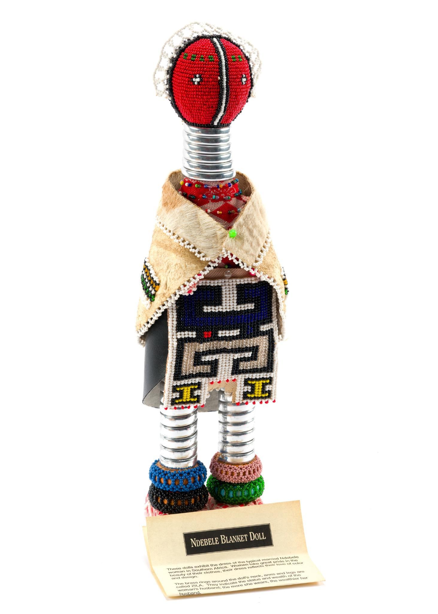 Ndebele Blanket Doll: These dolls depict the attire of a typical married Ndebele woman in Southern Africa. Includes a paper explaining the history. In good condition. Measures 16-1/2". 