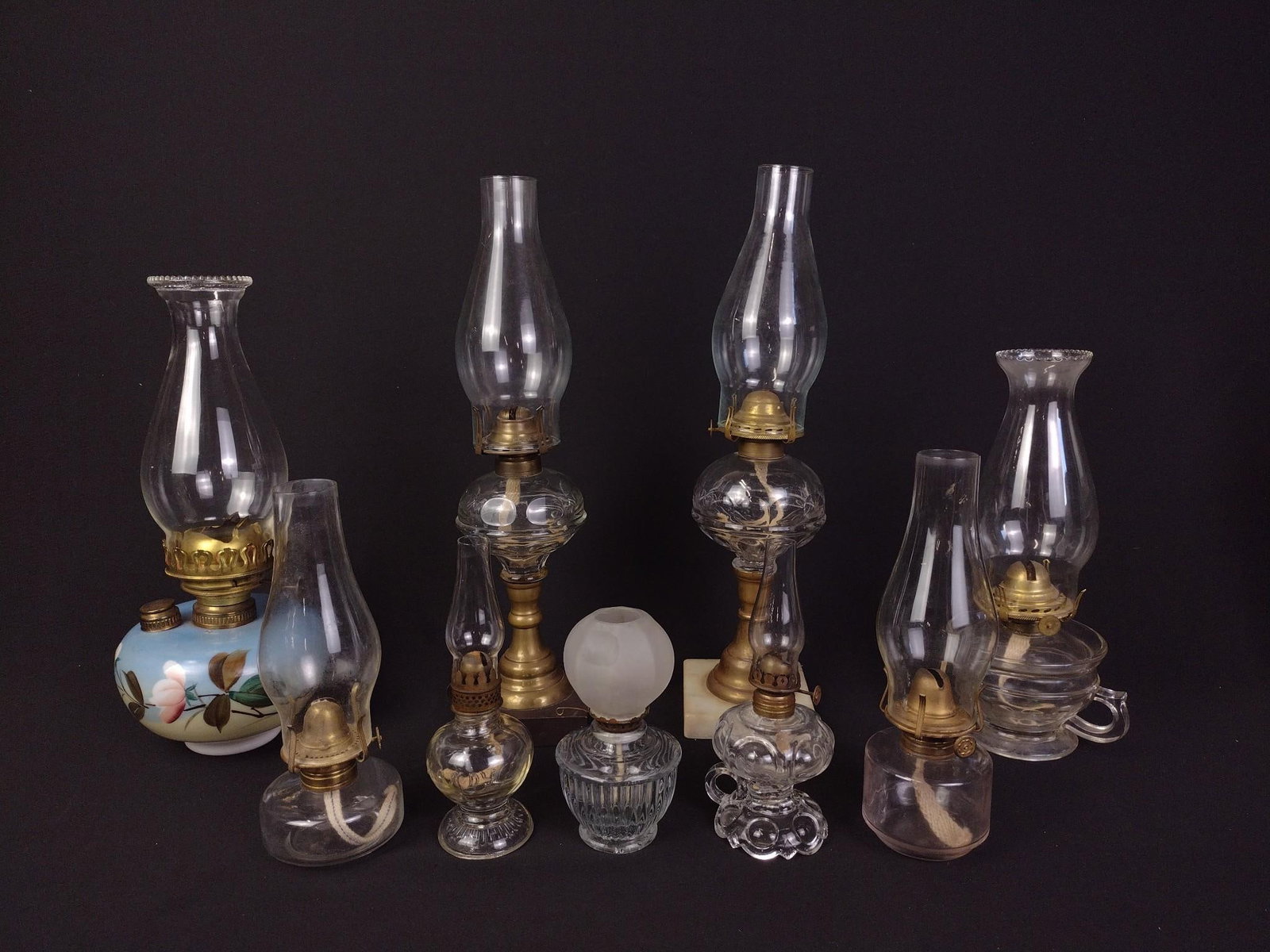 9 Vintage Oil Lamps: One with hand-painted base. Largest measures 4" x 4" x 16-1/2" and the smallest measures 2-1/2" x 2-1/2" x 8". 