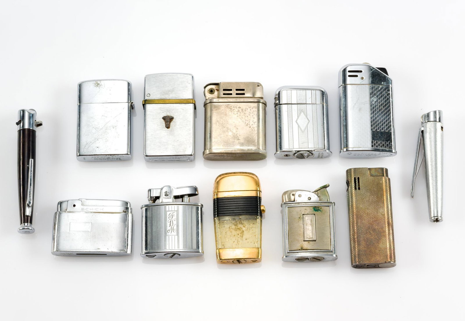 12 Vintage Lighters Incl. Rogers: The smallest lighter measures 1-1/2" tall; the largest measures 3-1/2". Also includes Schick, Scripto, Evans, Beattie Jet Lighter, Ronson, Kaywoodie, Thorens, Nimrod, Consul and Savinelli. 