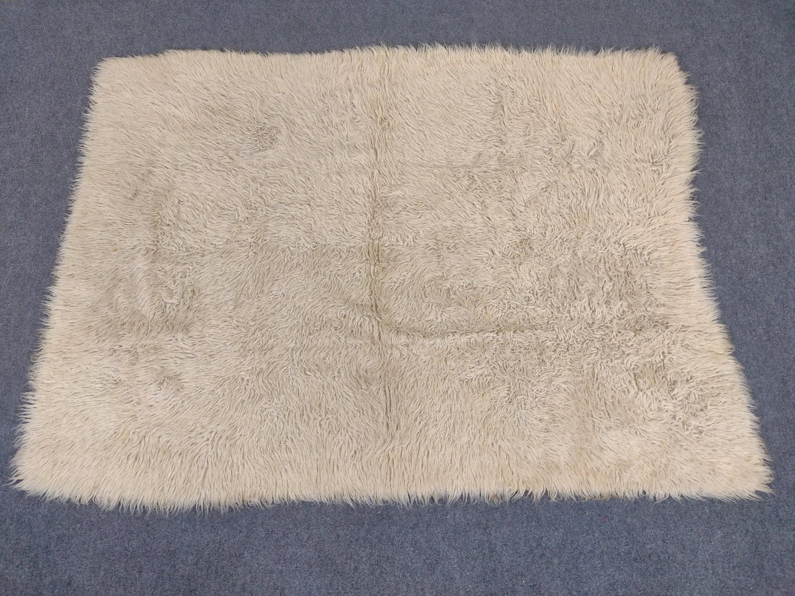 Greek Flokati Rug: Measures 96" x 71". Made of sheep’s wool.