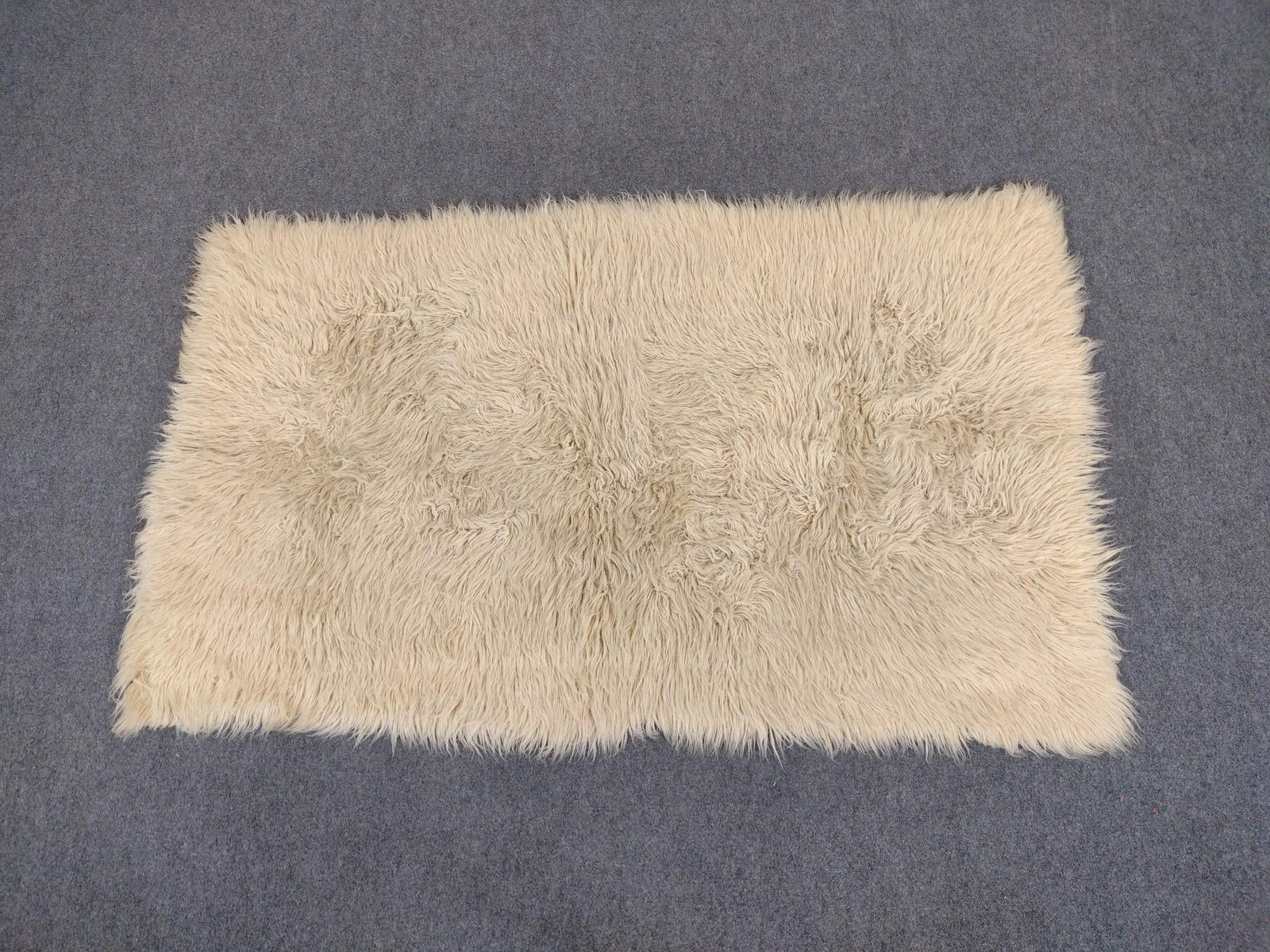 Greek Flokati Rug: Measures 96" x 71". Made of sheep’s wool.