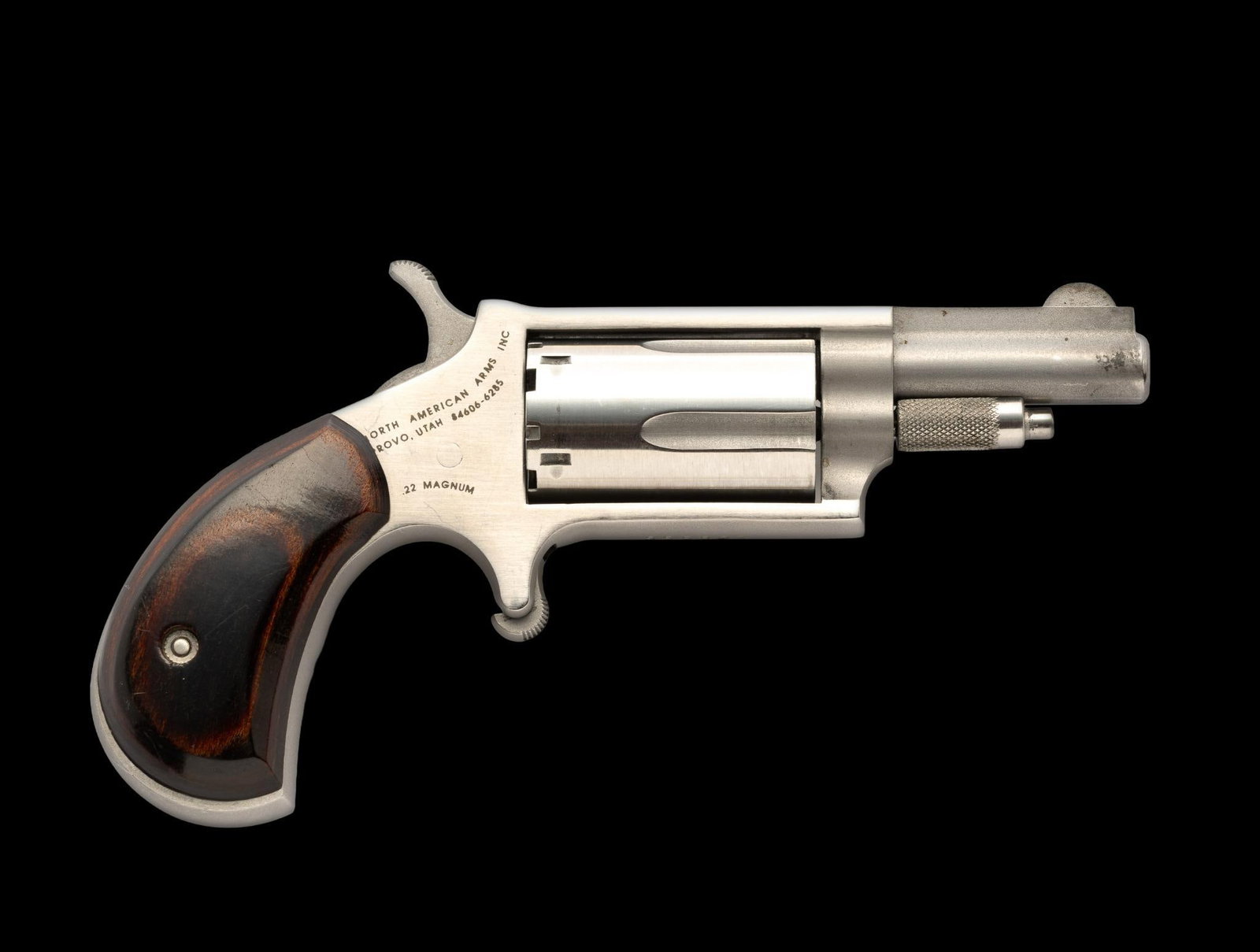 North American Arms Derringer, Cal. .22 Magnum: Serial No. Z08335 This tiny single action derringer was built by North American Arms of Provo, Utah. Action is tight and overall condition is excellent. Stainless steel construction and hardwood