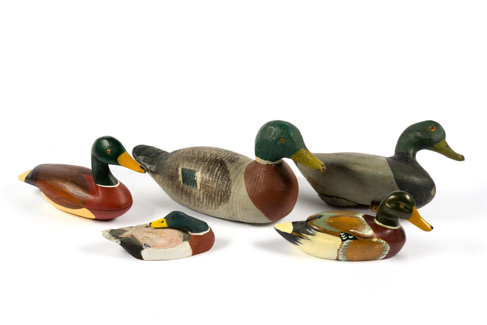 5 Wooden Duck Decoys: Largest measures 16-1/4" x 7" x 8" and the smallest measures 7-3/4" x 3". Smallest duck signed on bottom. 