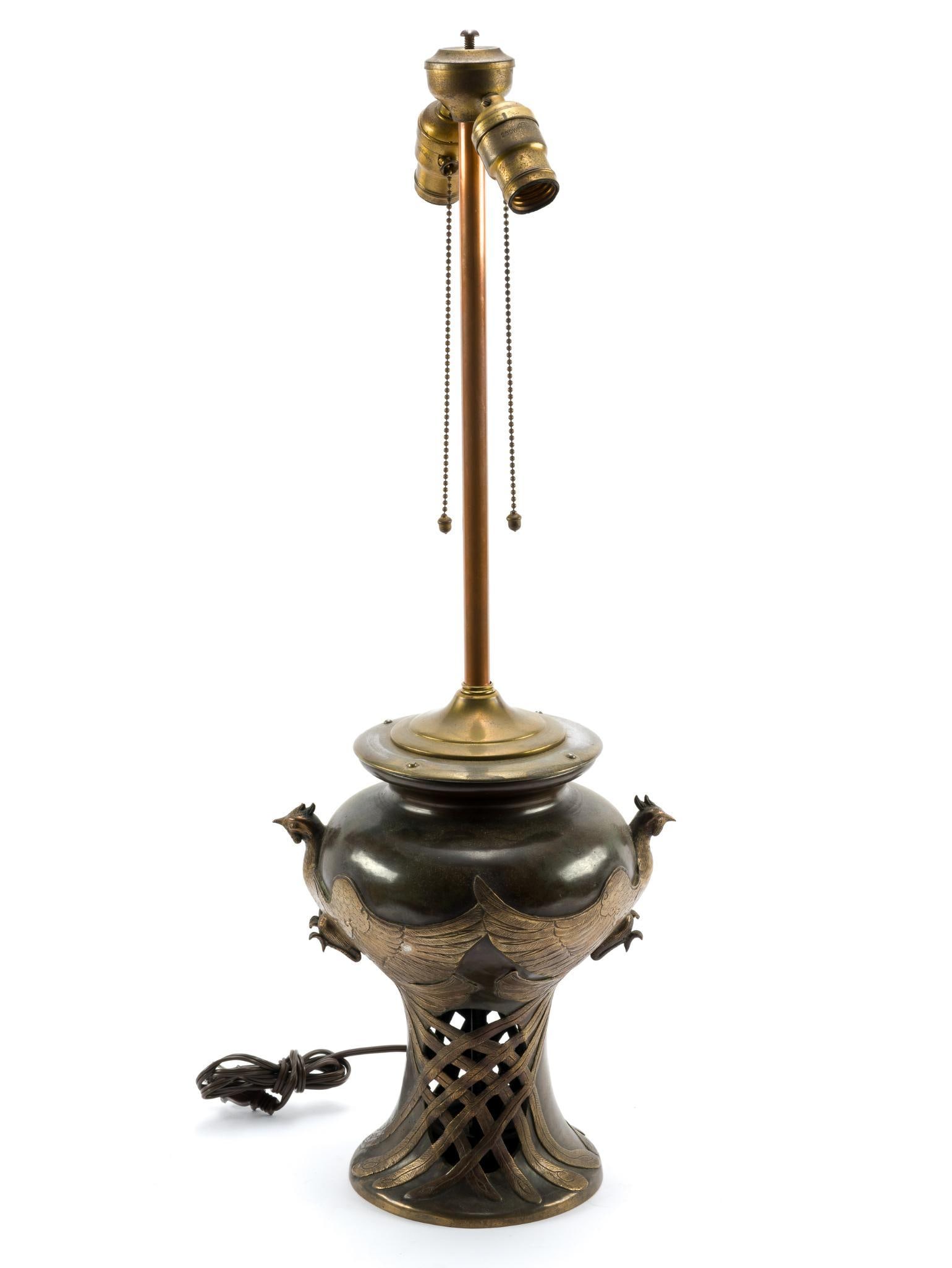 Antique Japanese Bronze Decorative Lamp: Bronze Decorative Japanese Meiji-style lamp. Depicts two birds with their wings wrapped around the base. The lamp is in good condition, consistent with age and use on the brass. No lamp shade or light