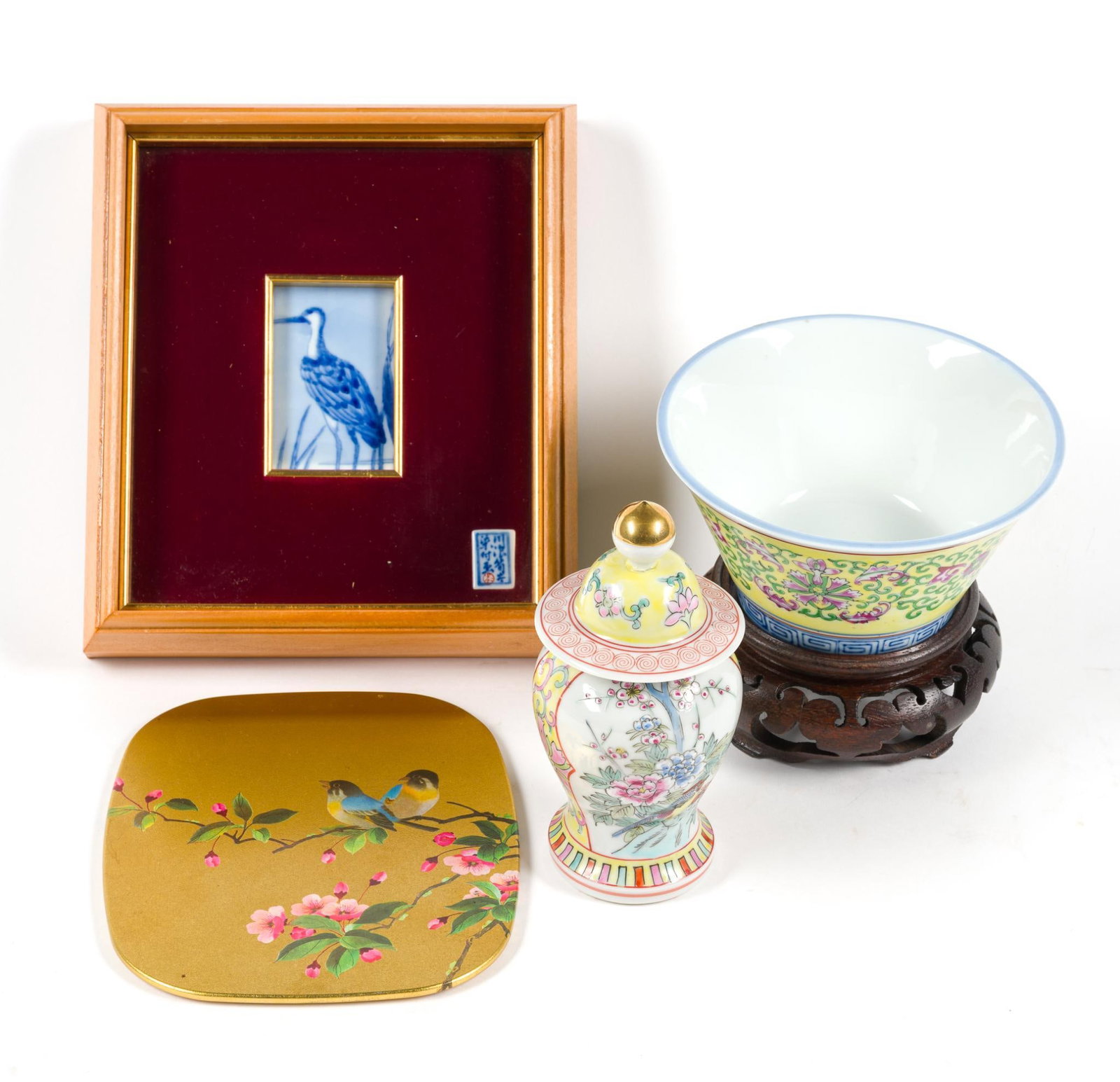 Japanese and Chinese Decoratives: Includes a framed Japanese porcelain tile, a Japan-made bowl in the Famille Jaune style, a Chinese famille rose miniature lidded jar, an Asian trivet tray, and an Asian vase stand. All in good conditi