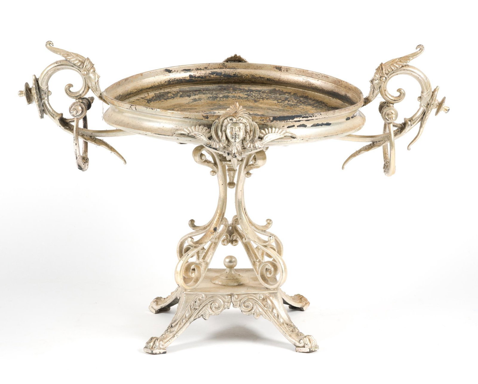 Victorian Silverplate Figural Centerpiece: Features intricate scrollwork handles and a mask motif; missing tray that would sit on top for serving. Condition consistent with age and use. Measures about 11-1/2" tall and ~16-3/4" long. 