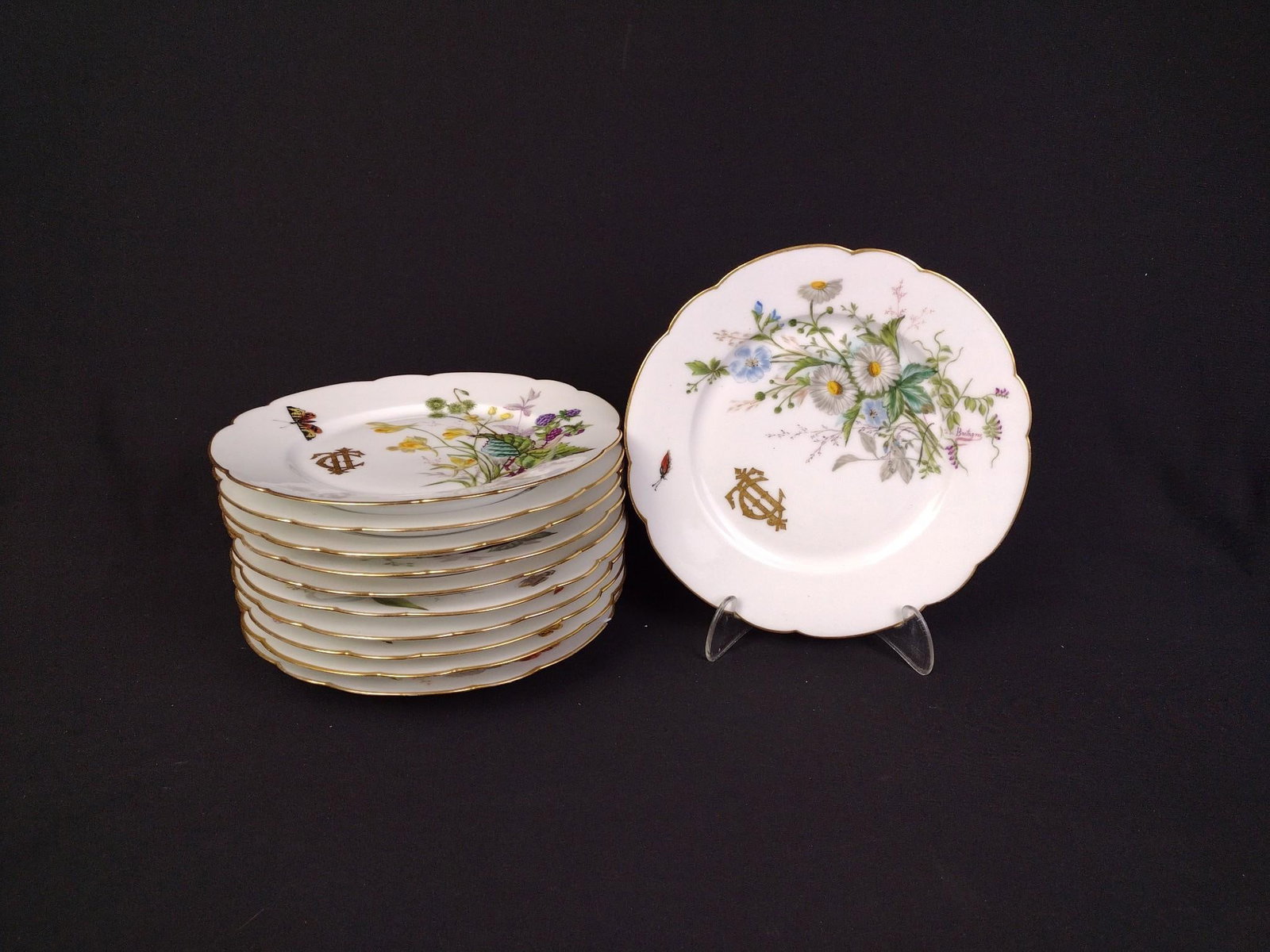 11 Hand Painted Antique Plates by F. De Bretagne: One of the plates has a small chip out of the rim. Plates measure 8-1/4" in diameter. 