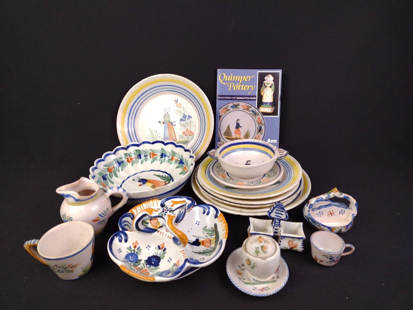Vintage Quimper Pottery: Some of the pieces have been repaired and have cracks throughout. Largest piece measures 9-1/4" in diameter, smallest piece measures 3-1/4" x 1-3/8" x 3-1/2". Also comes with a "Quimper Pottery" book