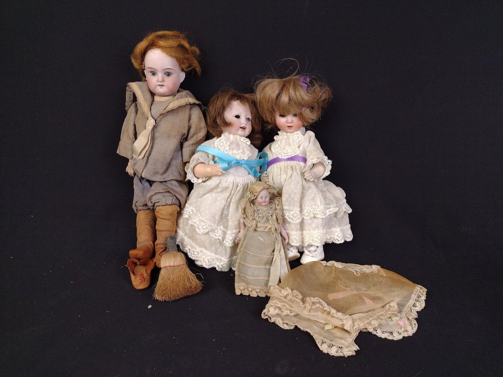 4 Antique Bisque Head Dolls: One doll is missing her eyes, all have expected wear associated with age and use. 