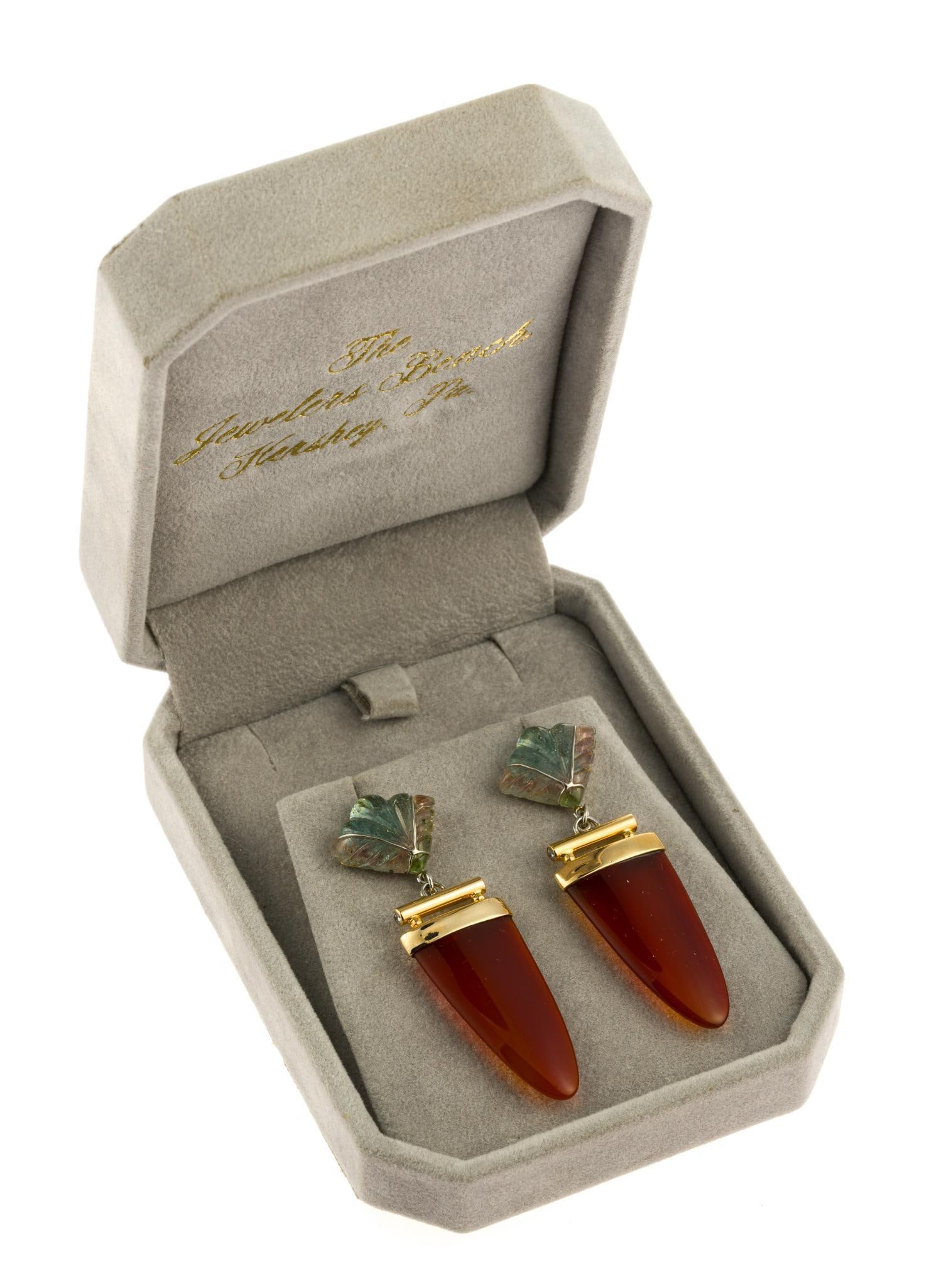 14K Gold, Carnelian, and Tourmaline Drop Earrings: A 2" length pair of earrings in yellow gold with carved watermelon tourmaline fan or leaf shaped tops and carnelian drops. They are marked 14k and weigh 11.9 grams. In original gift box from The Jewel
