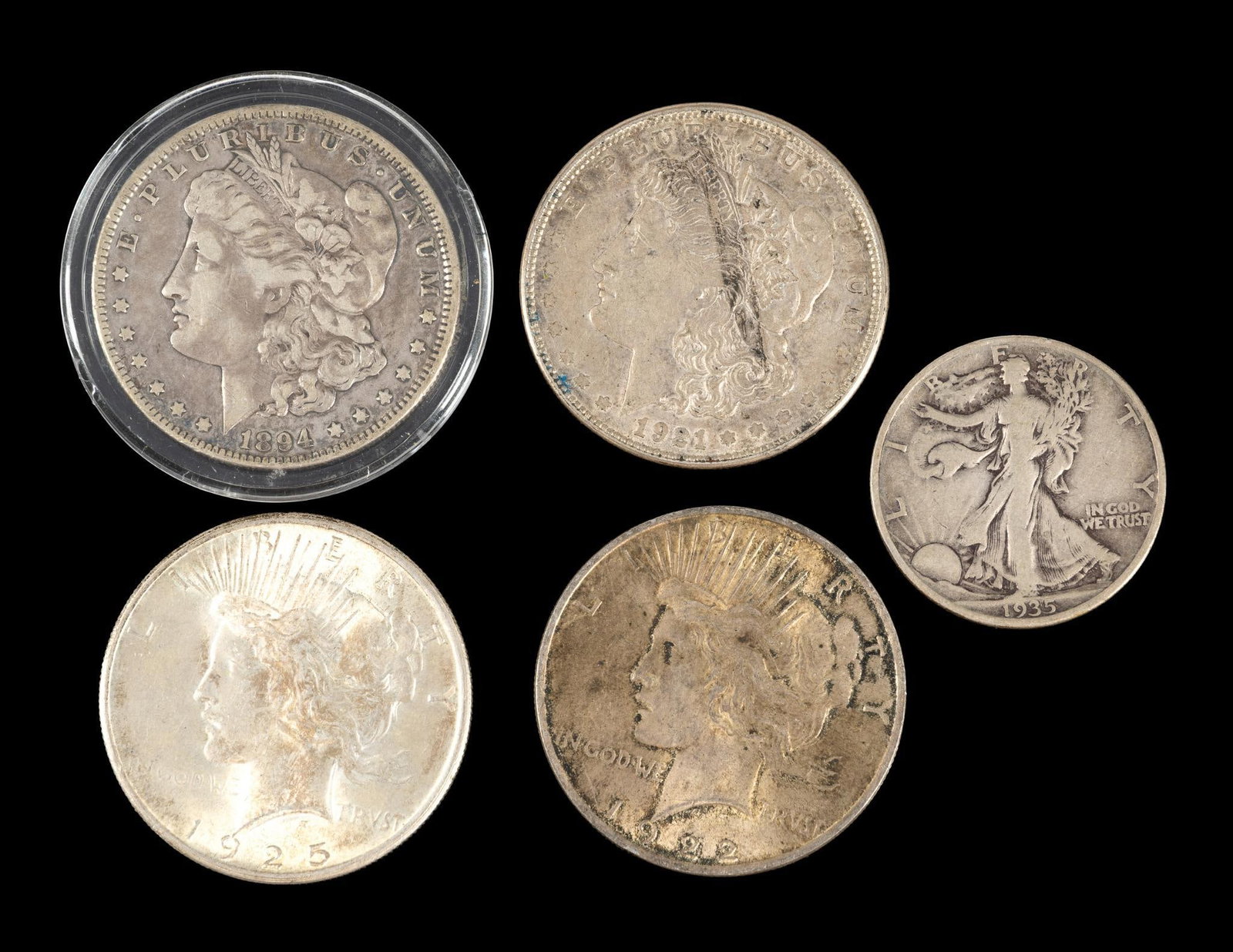 Four Silver Morgan And Peace Dollars: One Morgan an XF 1894-O. Also included is a Walking Liberty half dollar.