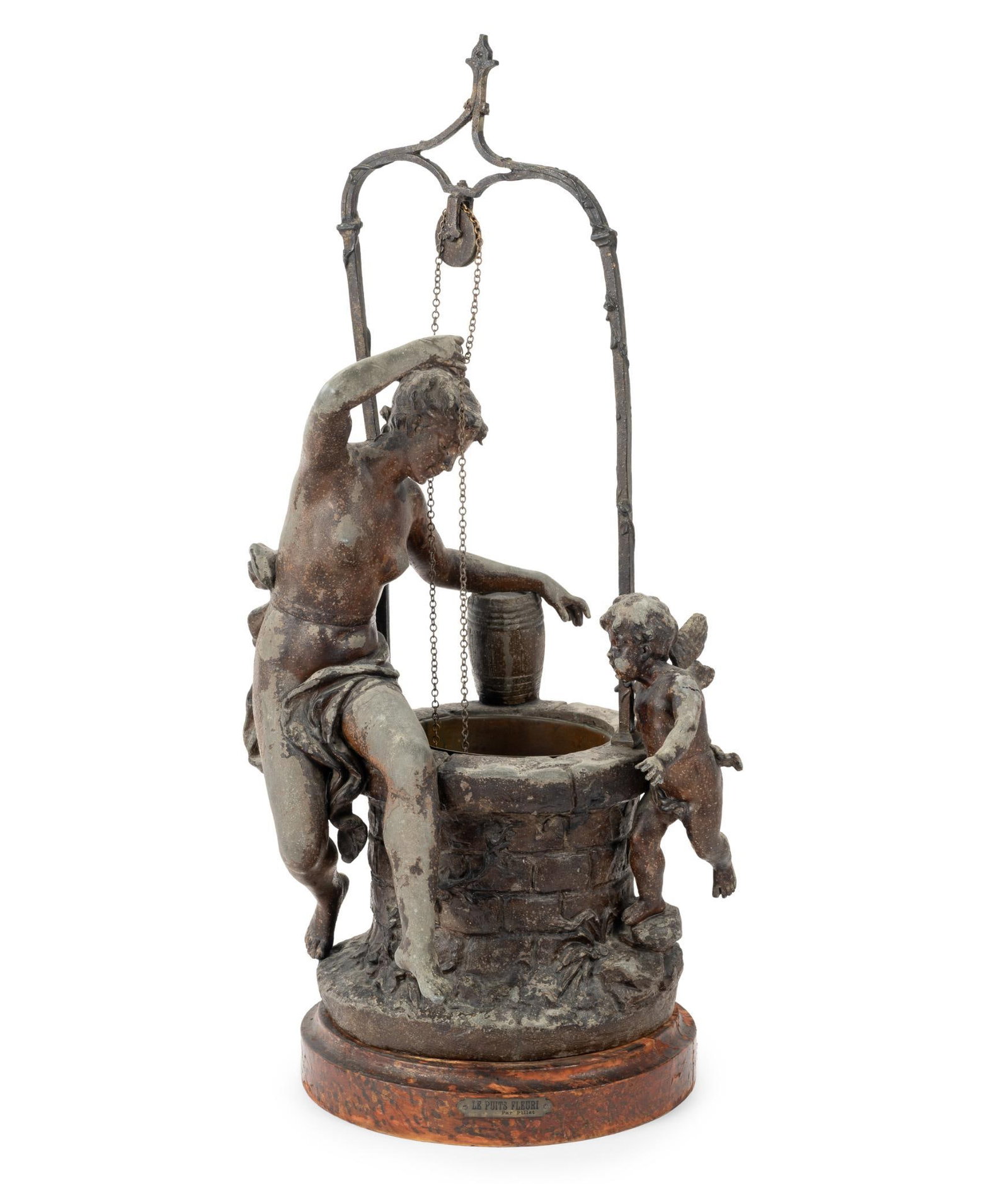 Leon Pillet Spelter Bronze Figural Sculpture: The piece is 24" in height on a 2" base with the nameplate "Le Puits Fleuri Par Pillet", The Wishing Well By (Leon) Pilet. It has the loss of one wing from the infant angel, a crack to the same