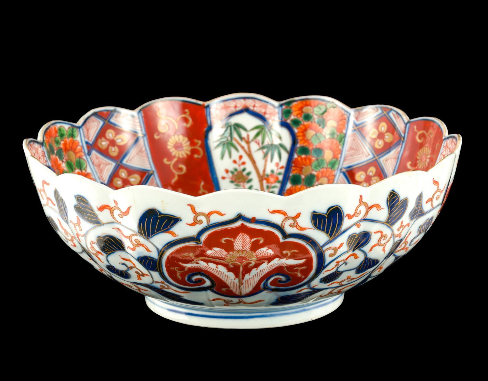 Japanese Imari Porcelain Center Bowl: A late 19th Century 11" diameter bowl with scalloped edges and panels to the interior while using a continuous floral design to the exterior. The base has three underglaze rings. The bowl has no