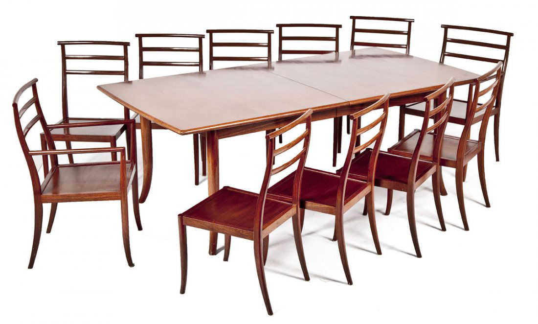 Modern Teak Dining Table and Chairs: DESCRIPTION: Dining table with eleven chairs (two arm, nine side). Open backs and solid seats. Table with skirt and flared legs. Includes two leaves. Teak. MEASUREMENTS: Table 83" x 44" top x 30" high